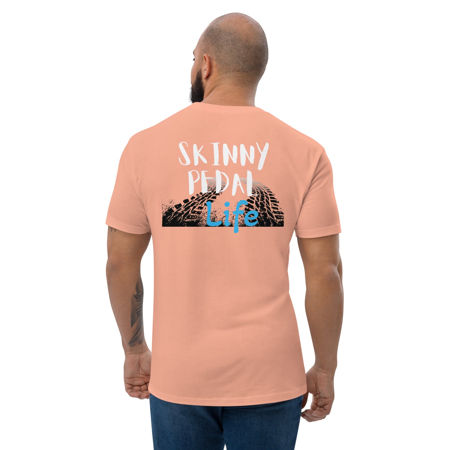 a man wearing a pink shirt that says skinnyy pedal