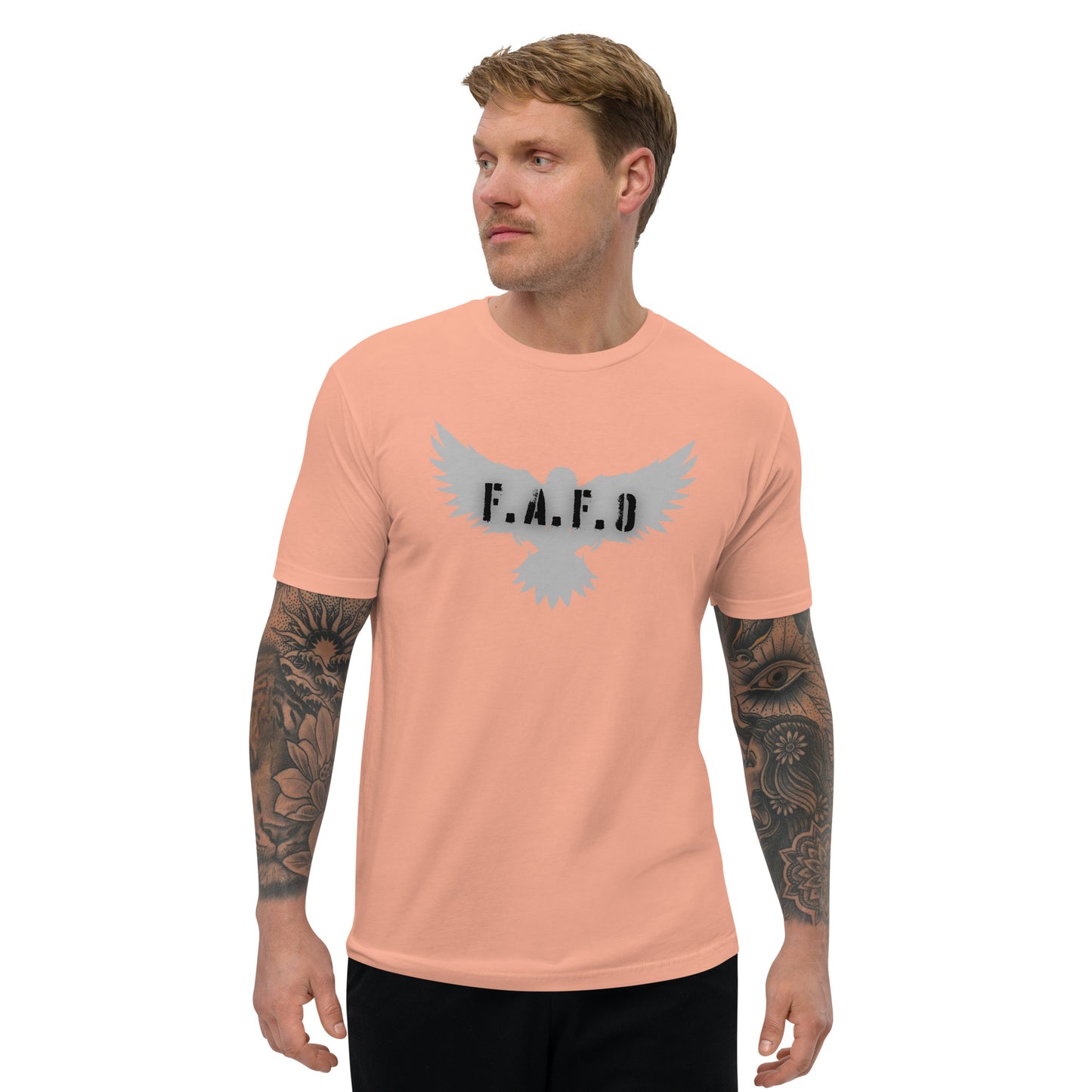 a man with a tattooed arm wearing a peach t - shirt