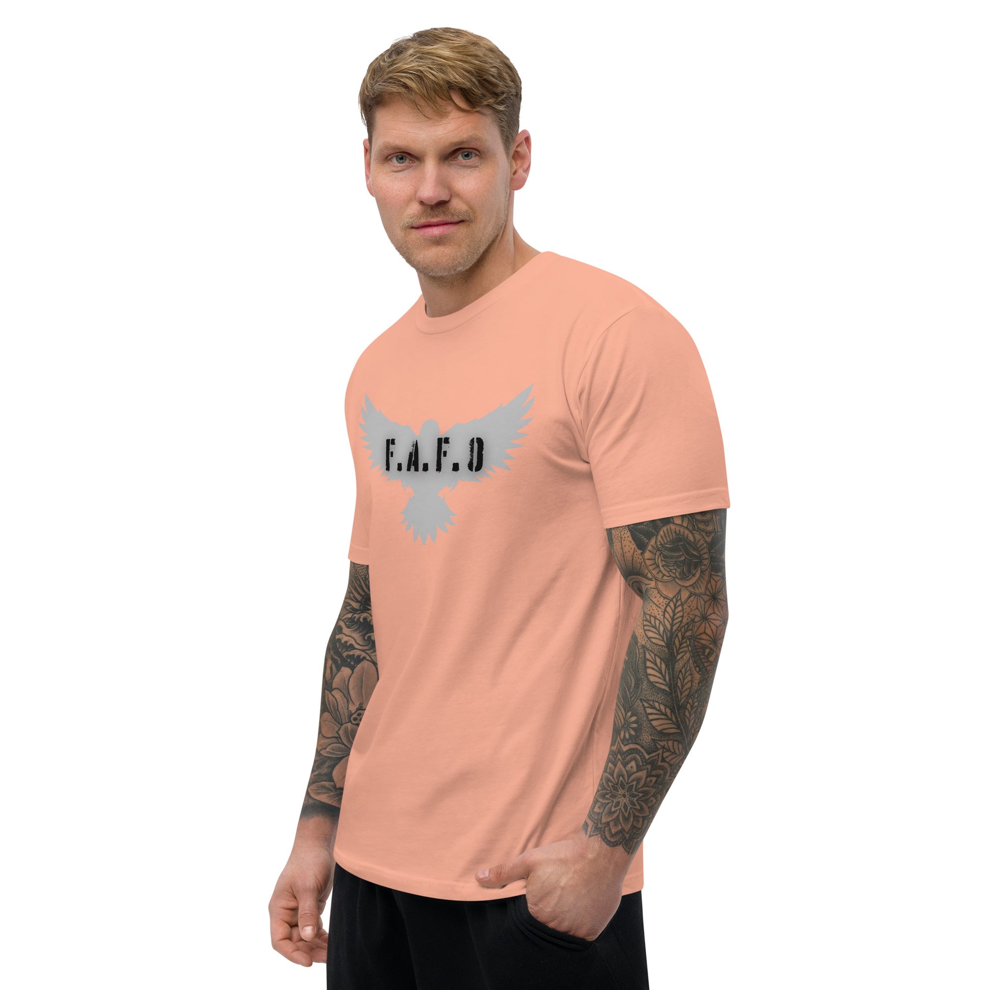 a man with a tattooed arm wearing a pink t - shirt