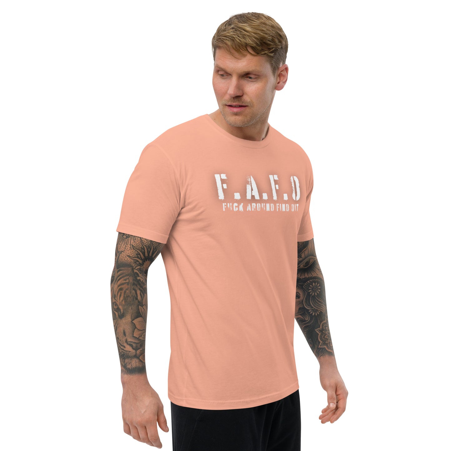 a man with a tattooed arm wearing a peach t - shirt