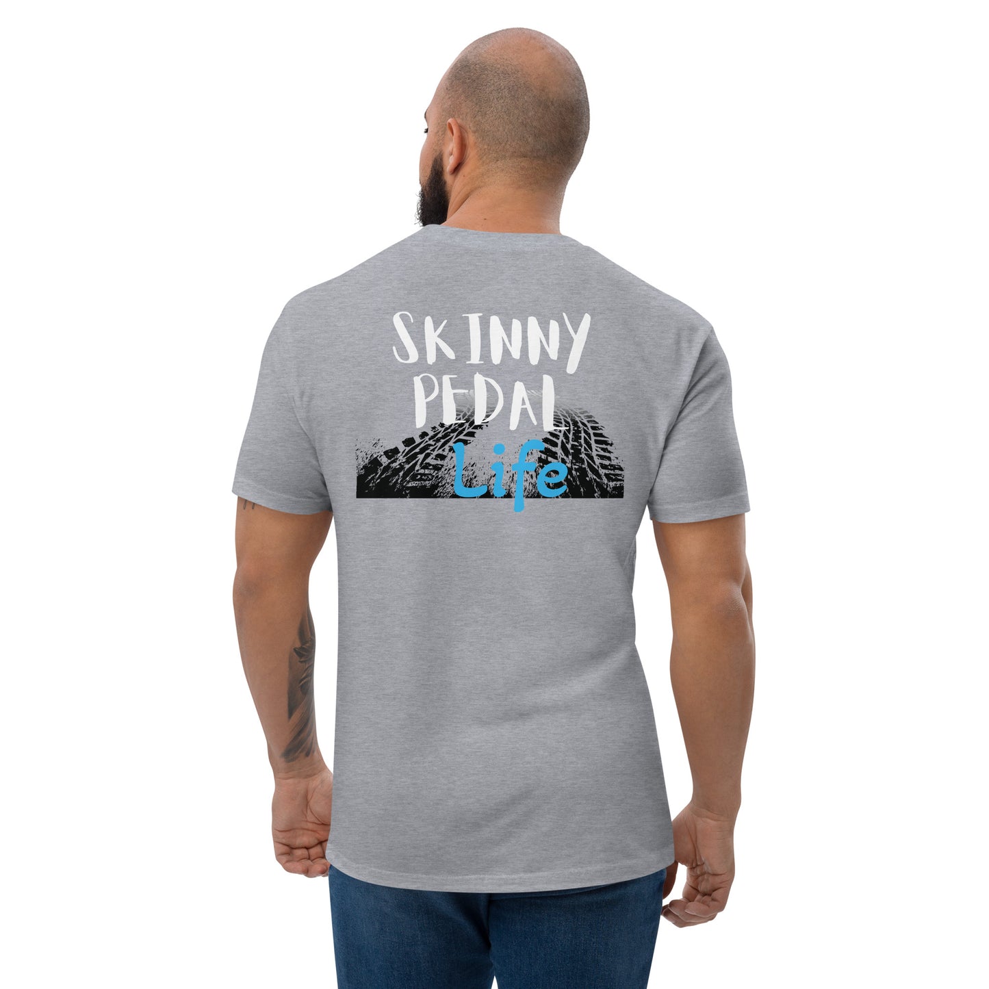 a man wearing a grey shirt that says skiinny pedal