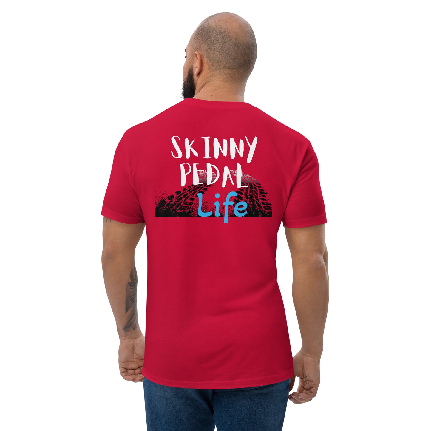 a man wearing a red shirt that says ski tiny pedal life