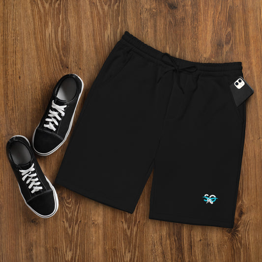 a pair of sneakers and a pair of black shorts on a wooden floor