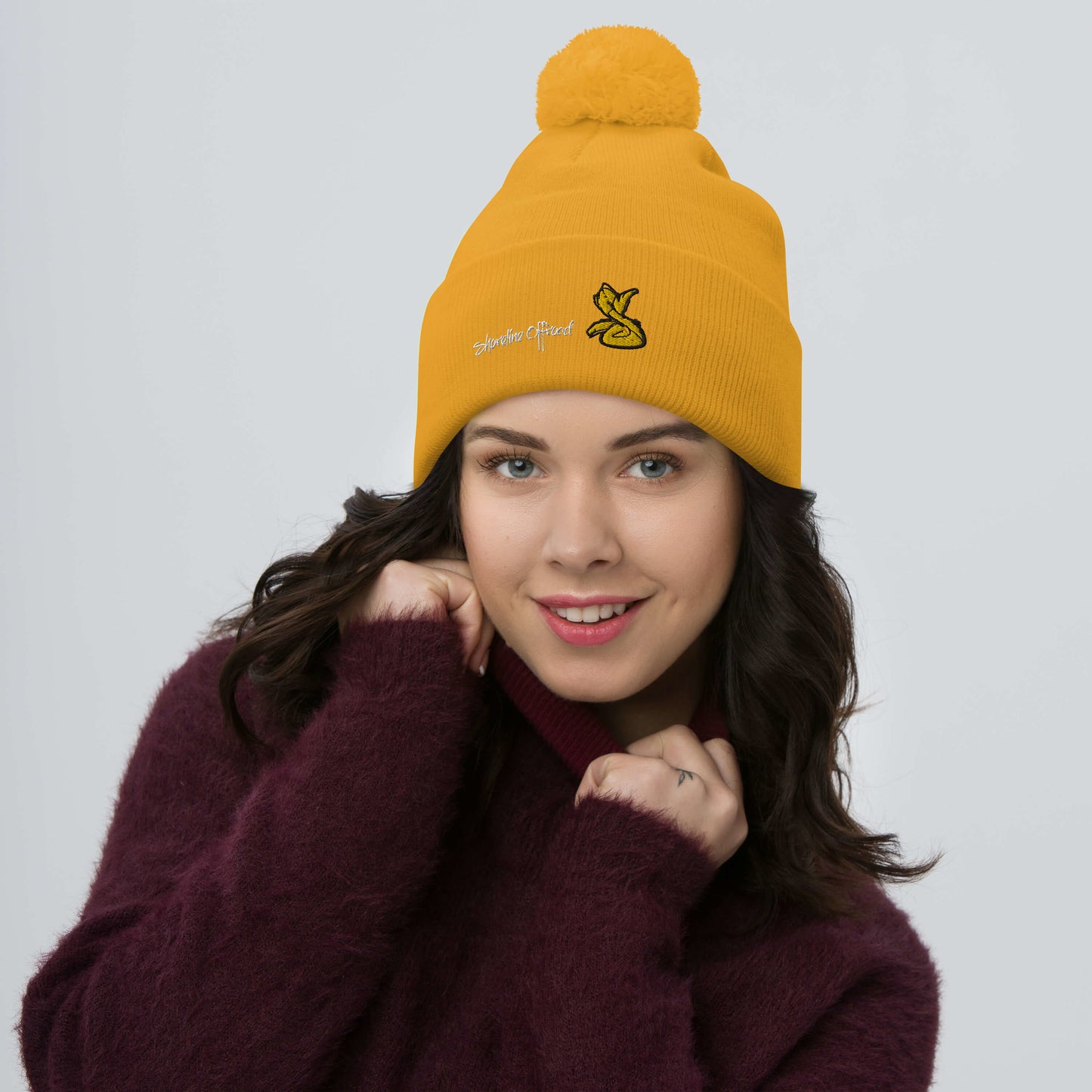 a woman wearing a beanie with a yellow pom - pom