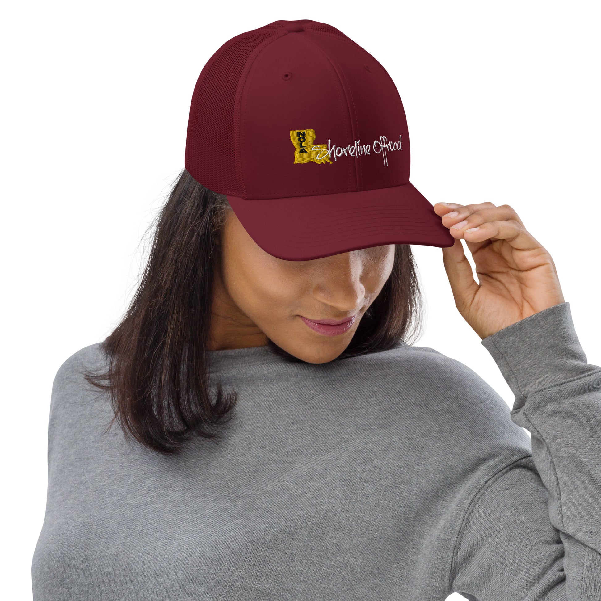 a woman wearing a maroon hat with a yellow logo