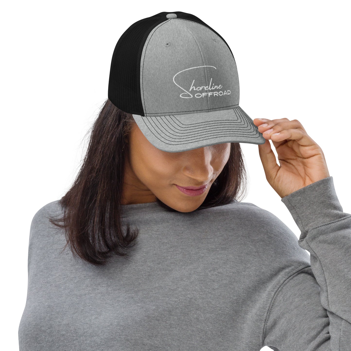 a woman wearing a gray and black trucker hat