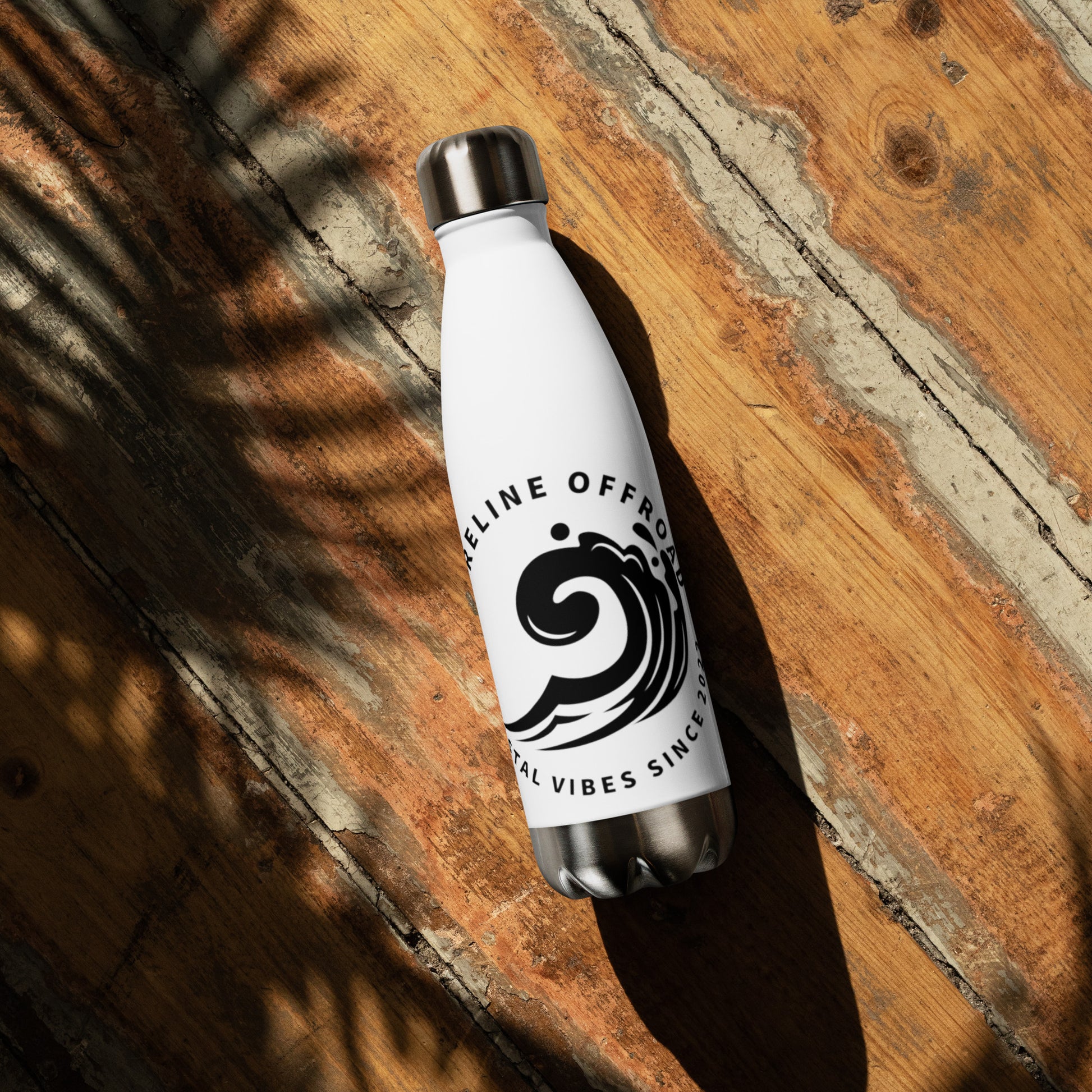 a white water bottle sitting on top of a wooden floor