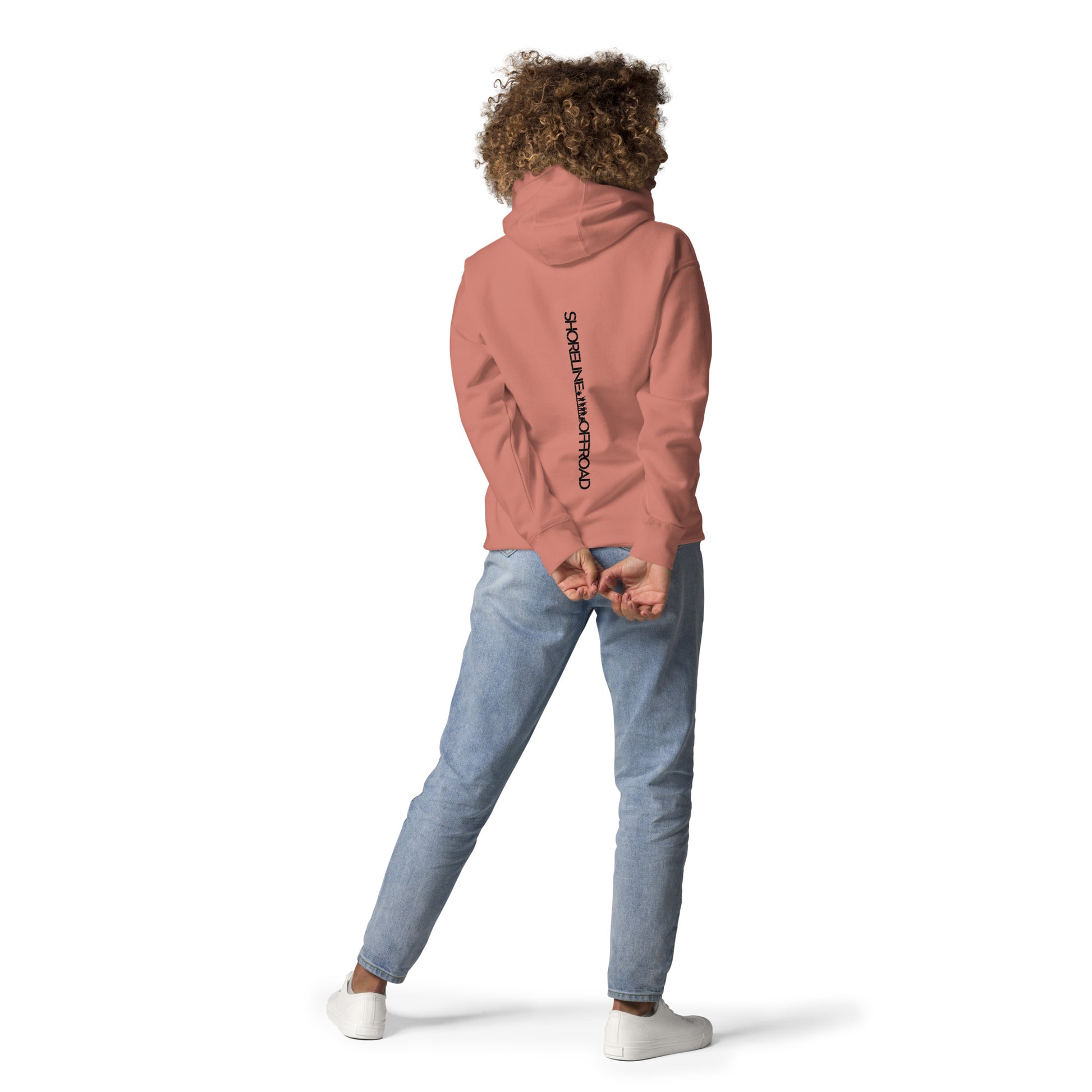 a woman in a pink hoodie is standing