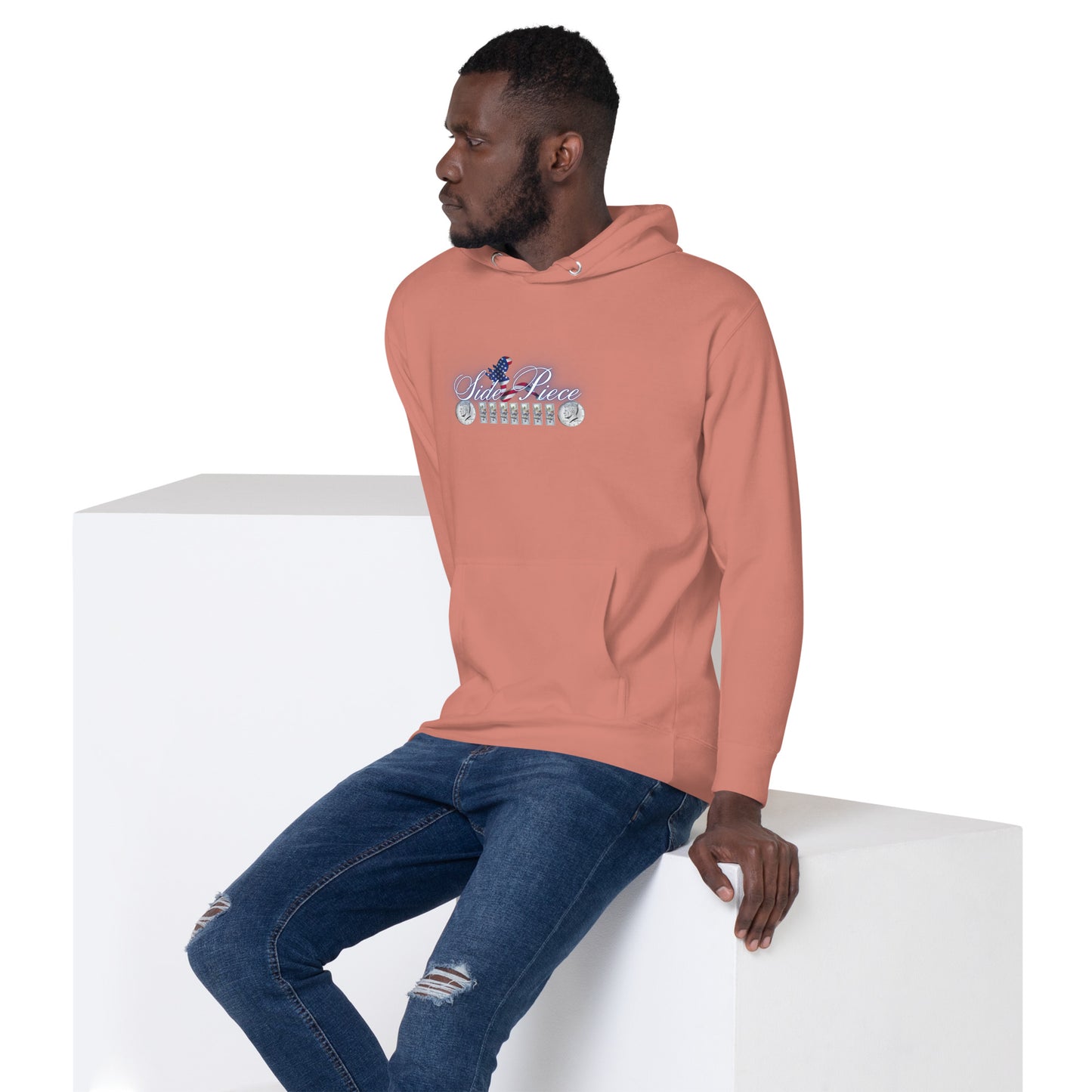 a man sitting on a block wearing a pink hoodie