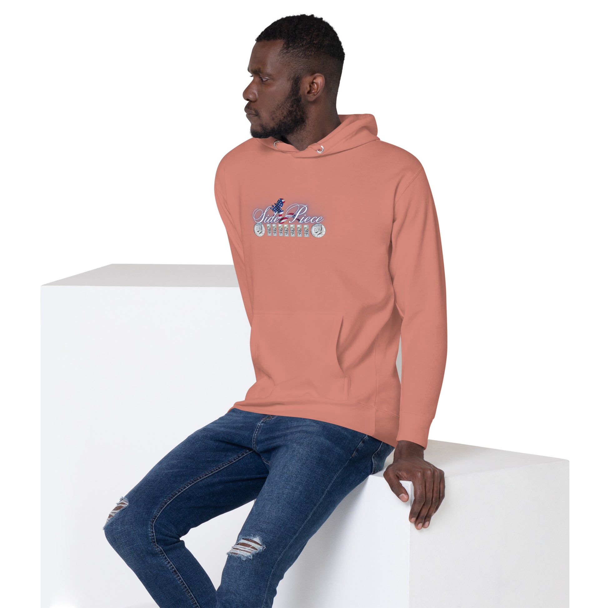 a man sitting on a block wearing a pink hoodie