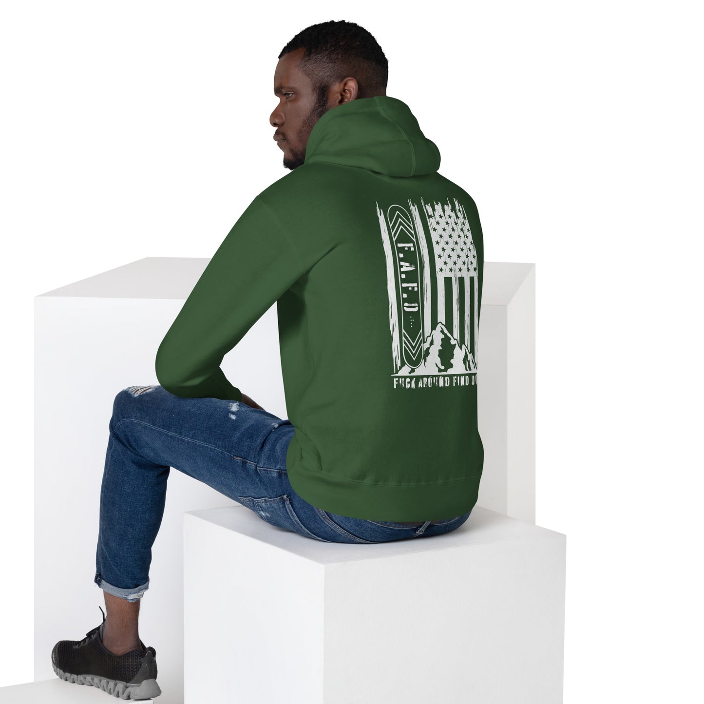 a man sitting on a block wearing a green hoodie