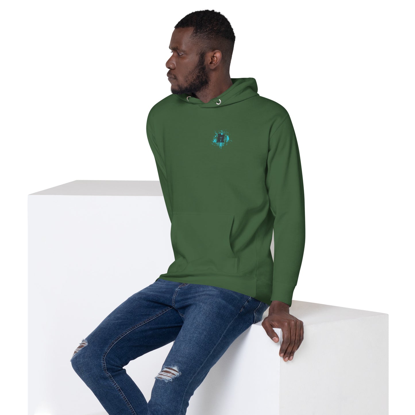 a man in a green hoodie sitting on a white block