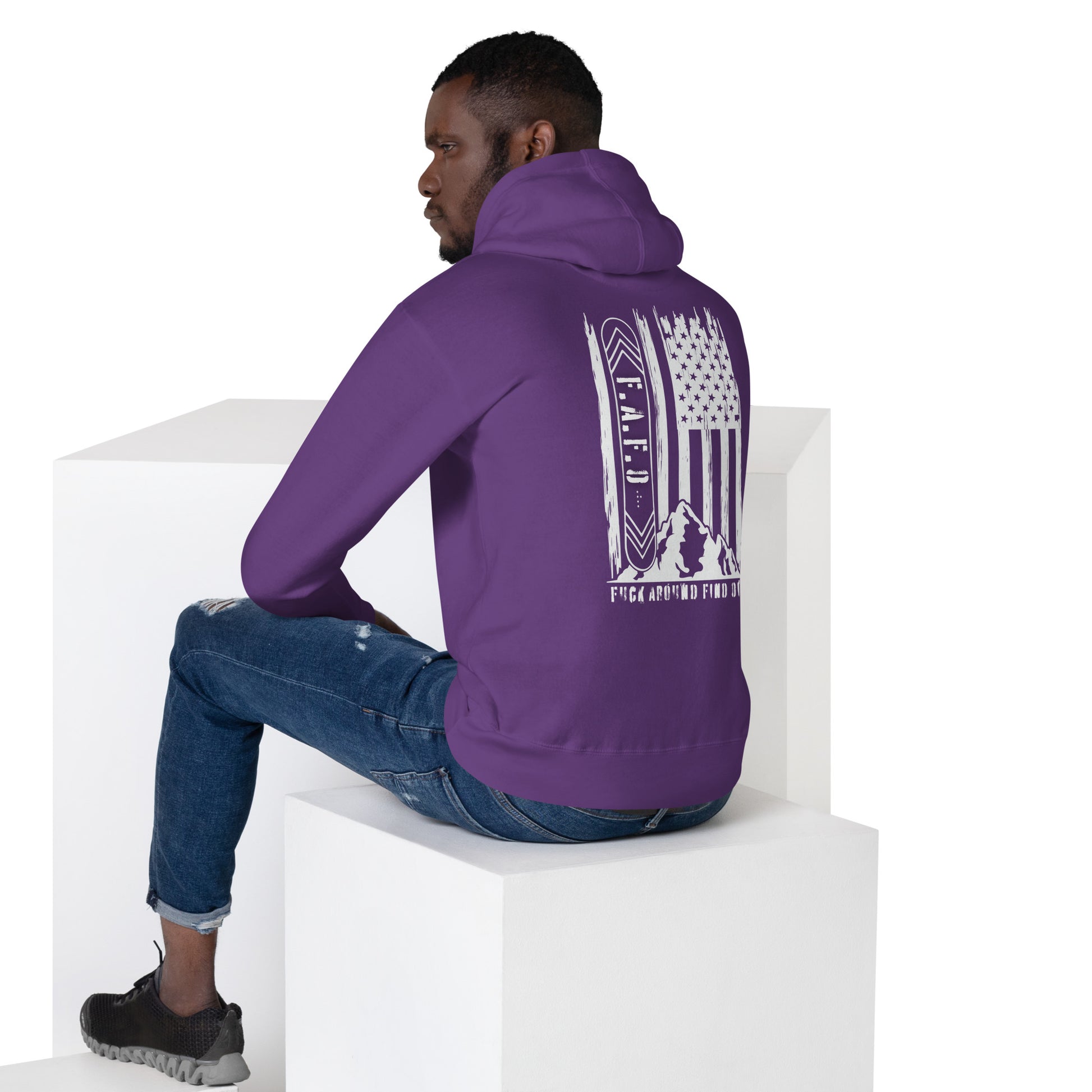 a man sitting on a block wearing a purple hoodie