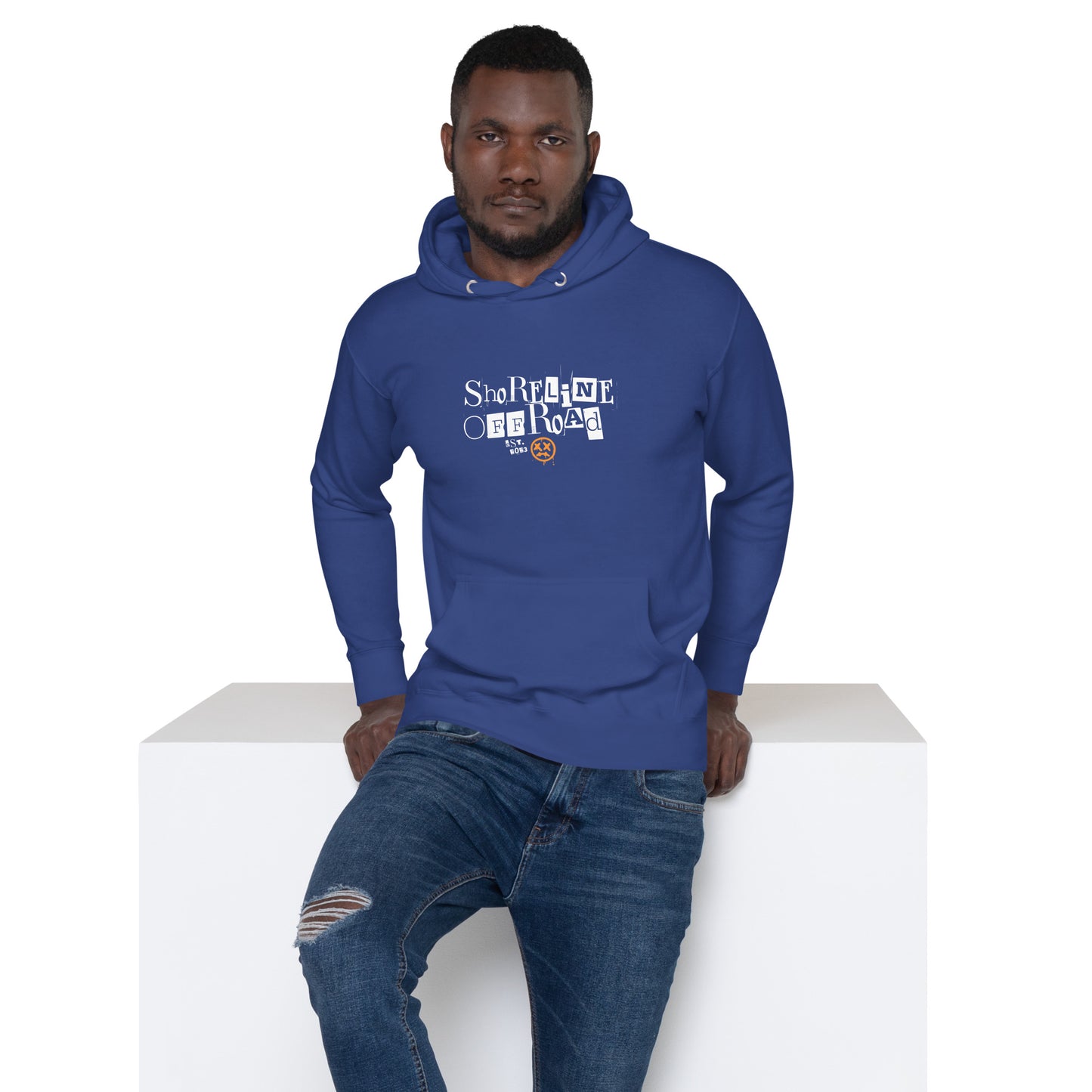 a man in a blue hoodie sitting on a white block