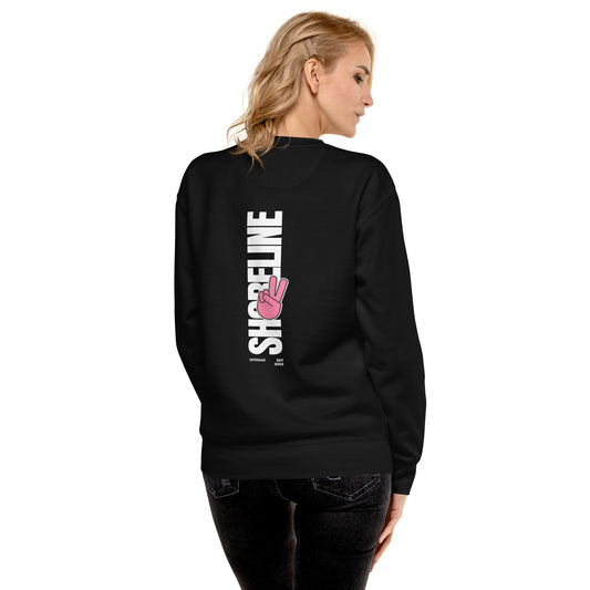 a woman wearing a black sweatshirt with a pink ribbon on it