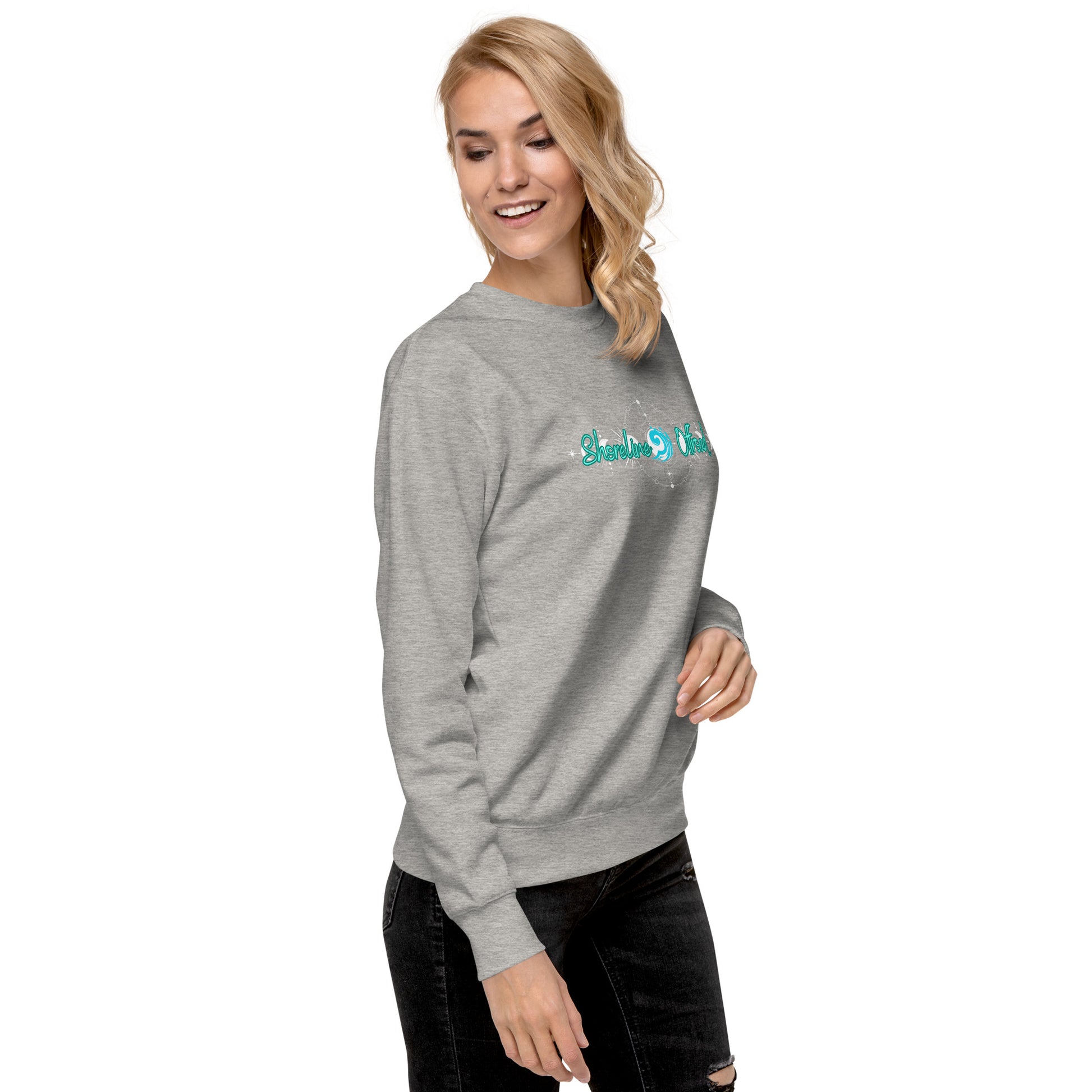 a woman wearing a grey sweatshirt with a green logo