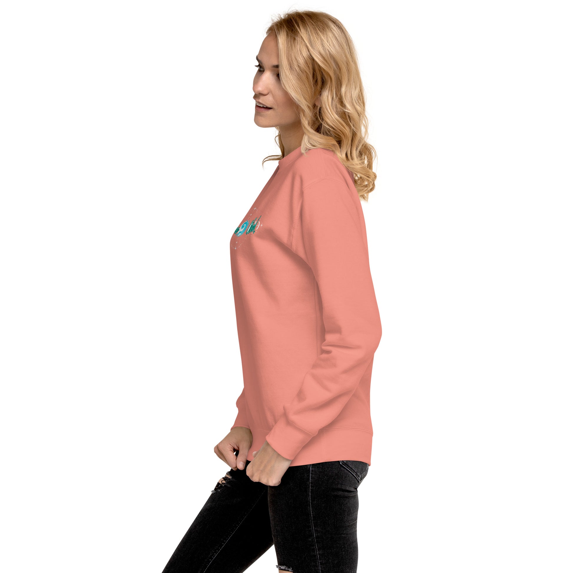 a woman wearing a pink sweatshirt and black jeans