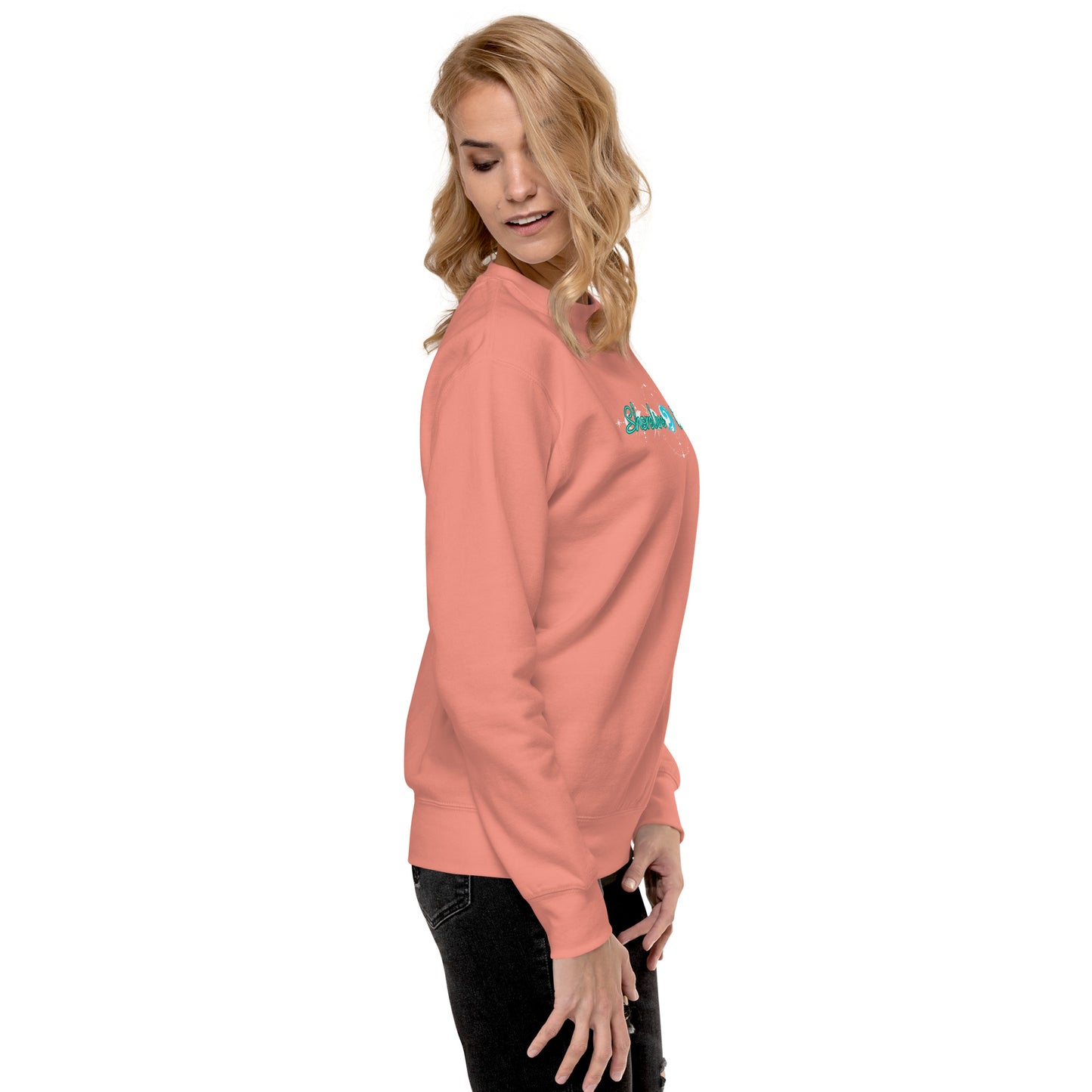 a woman wearing a pink sweatshirt and black pants