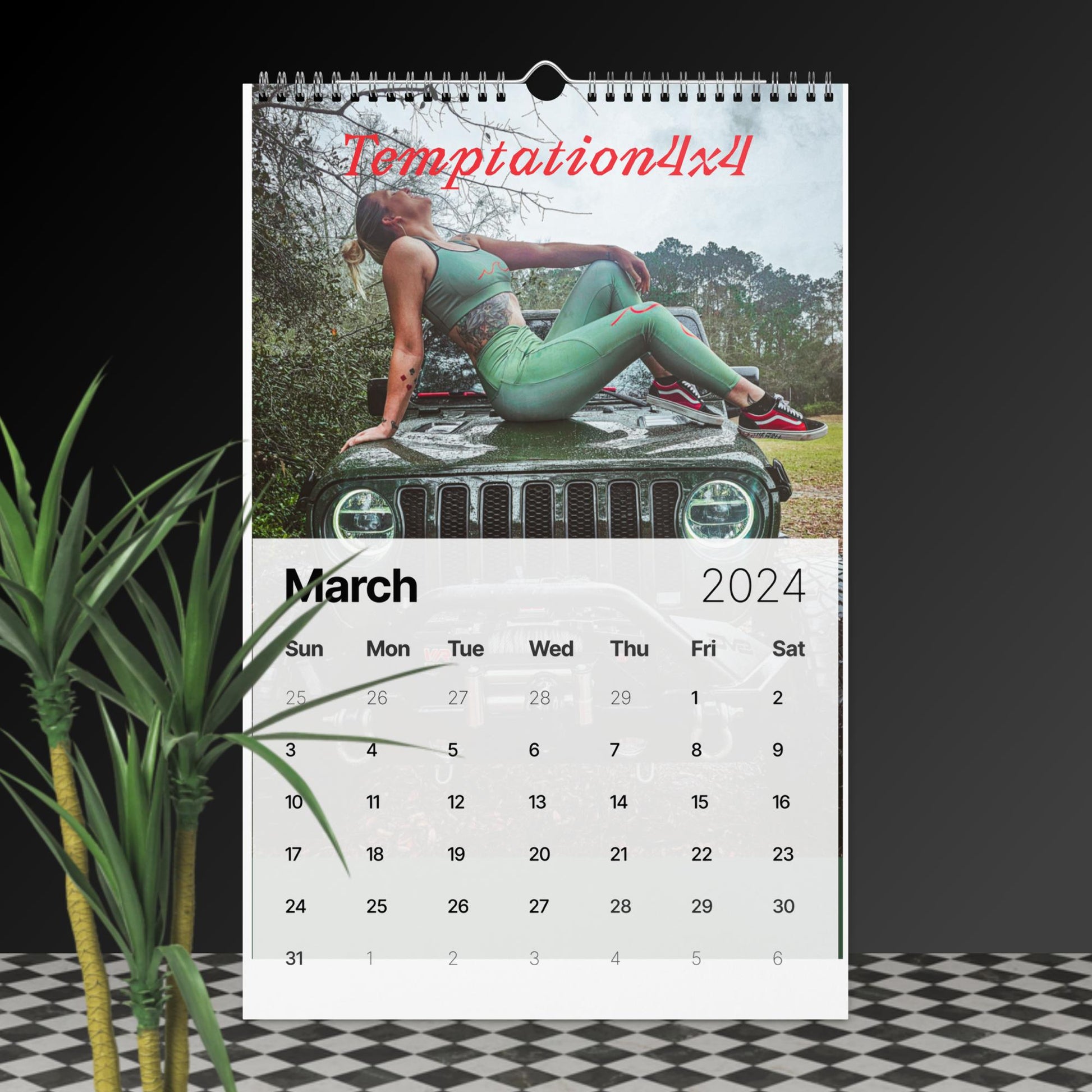 a calendar with a photo of a woman laying on a jeep