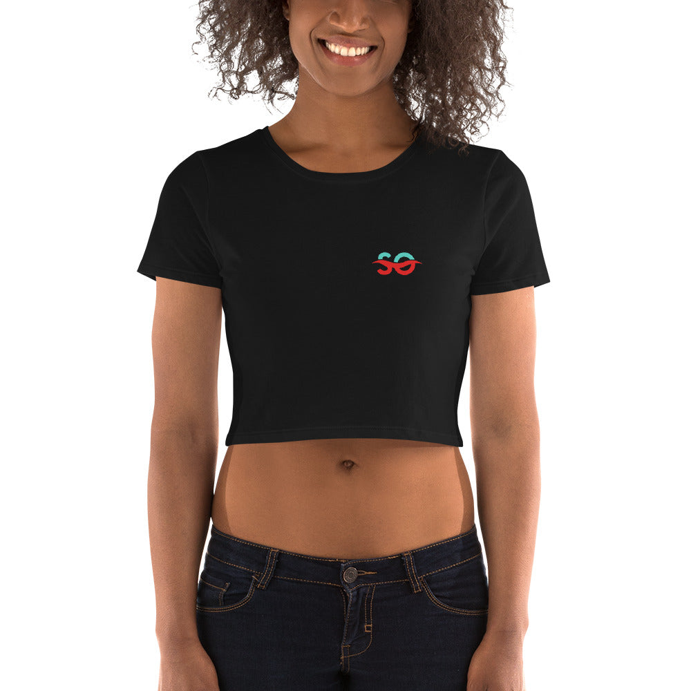 a woman wearing a black crop top with a red and green symbol on it