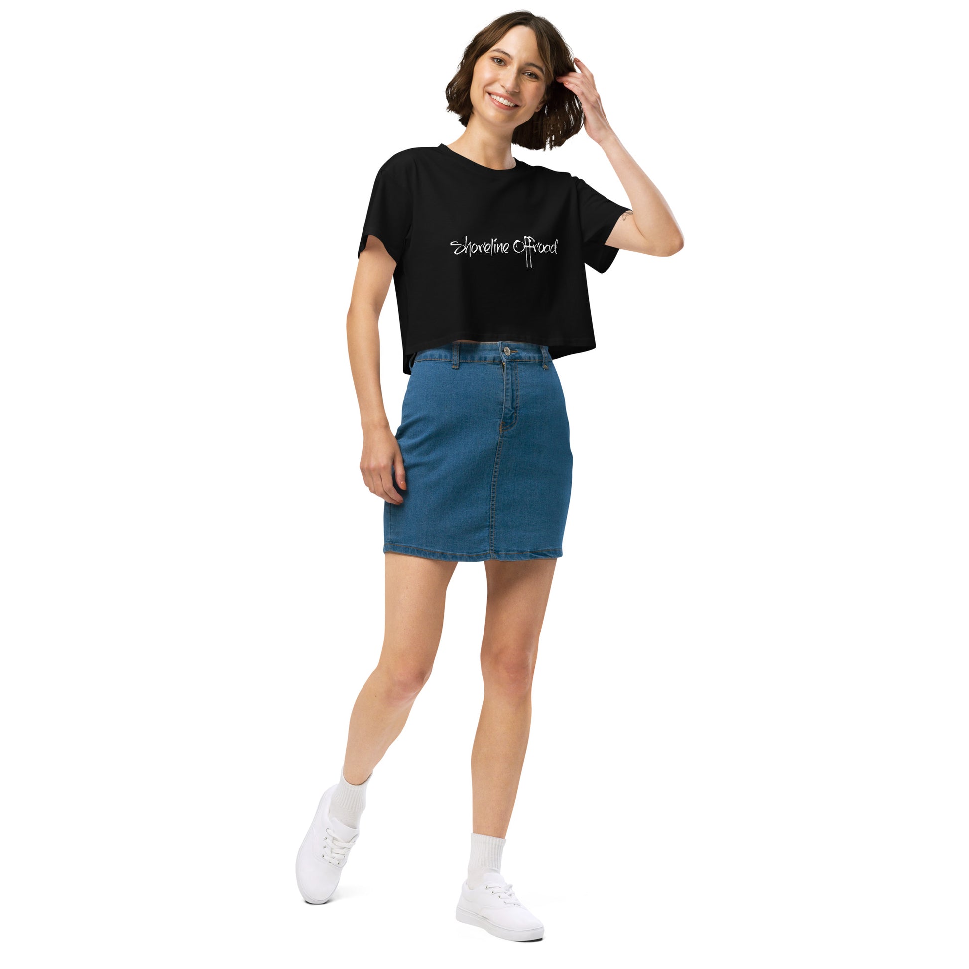 a woman wearing a black t - shirt and a denim skirt