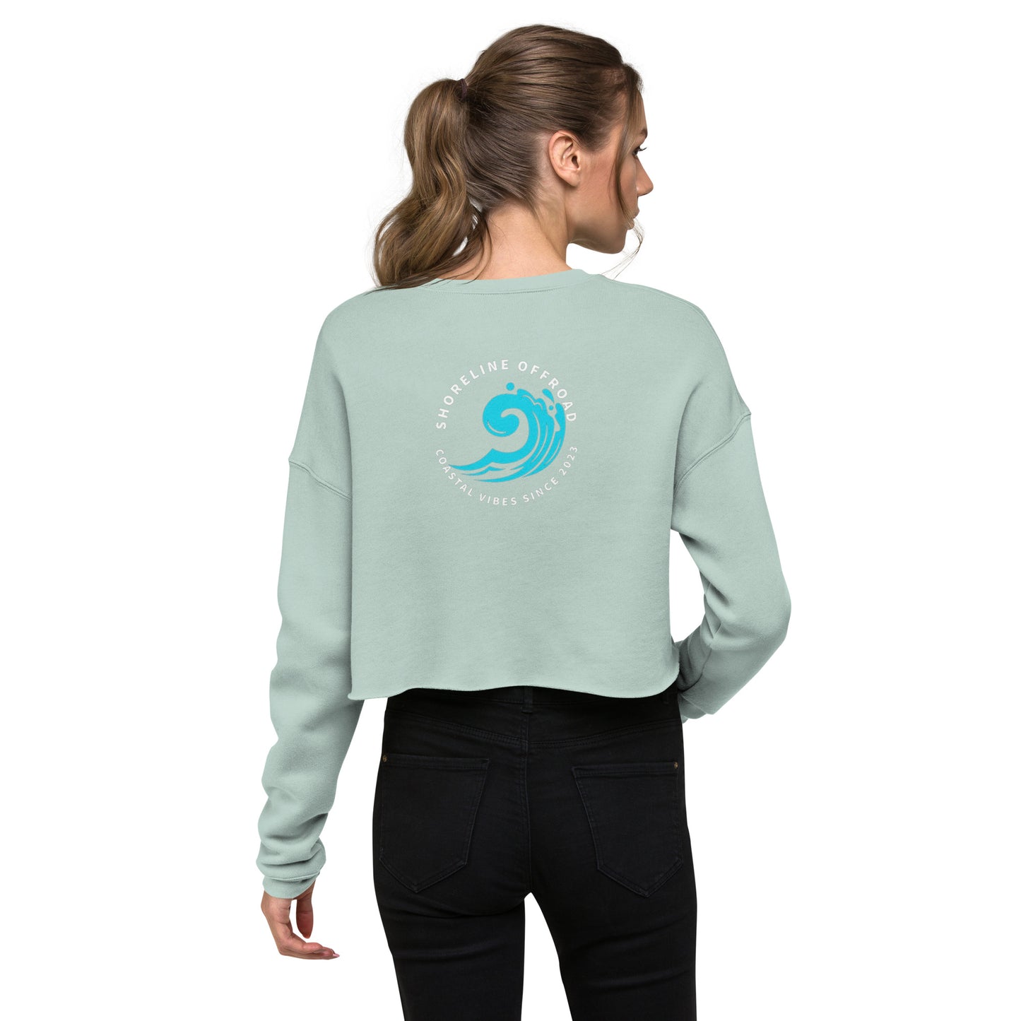 a woman wearing a light green sweatshirt with a blue wave on it