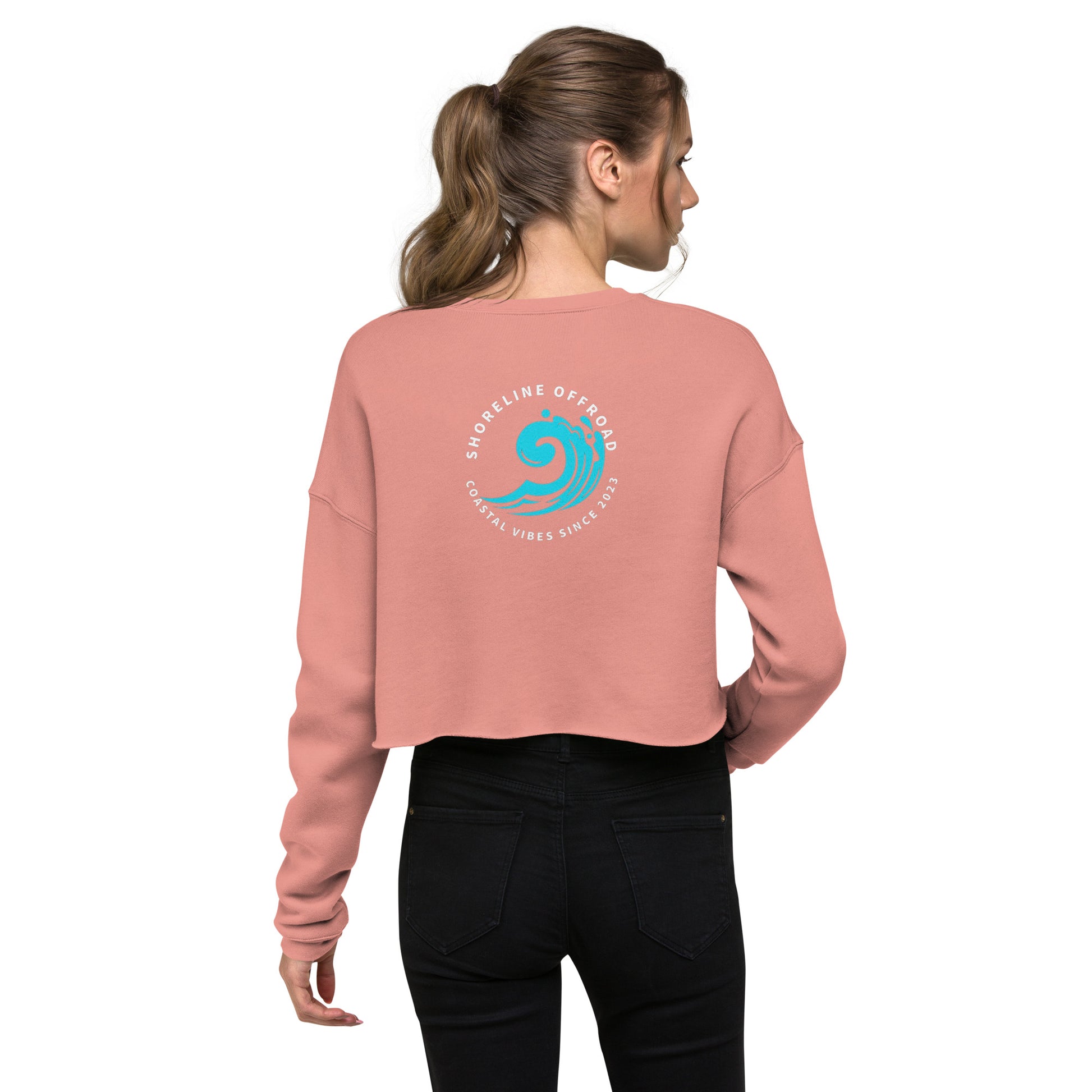 a woman wearing a pink sweatshirt with a blue wave on it