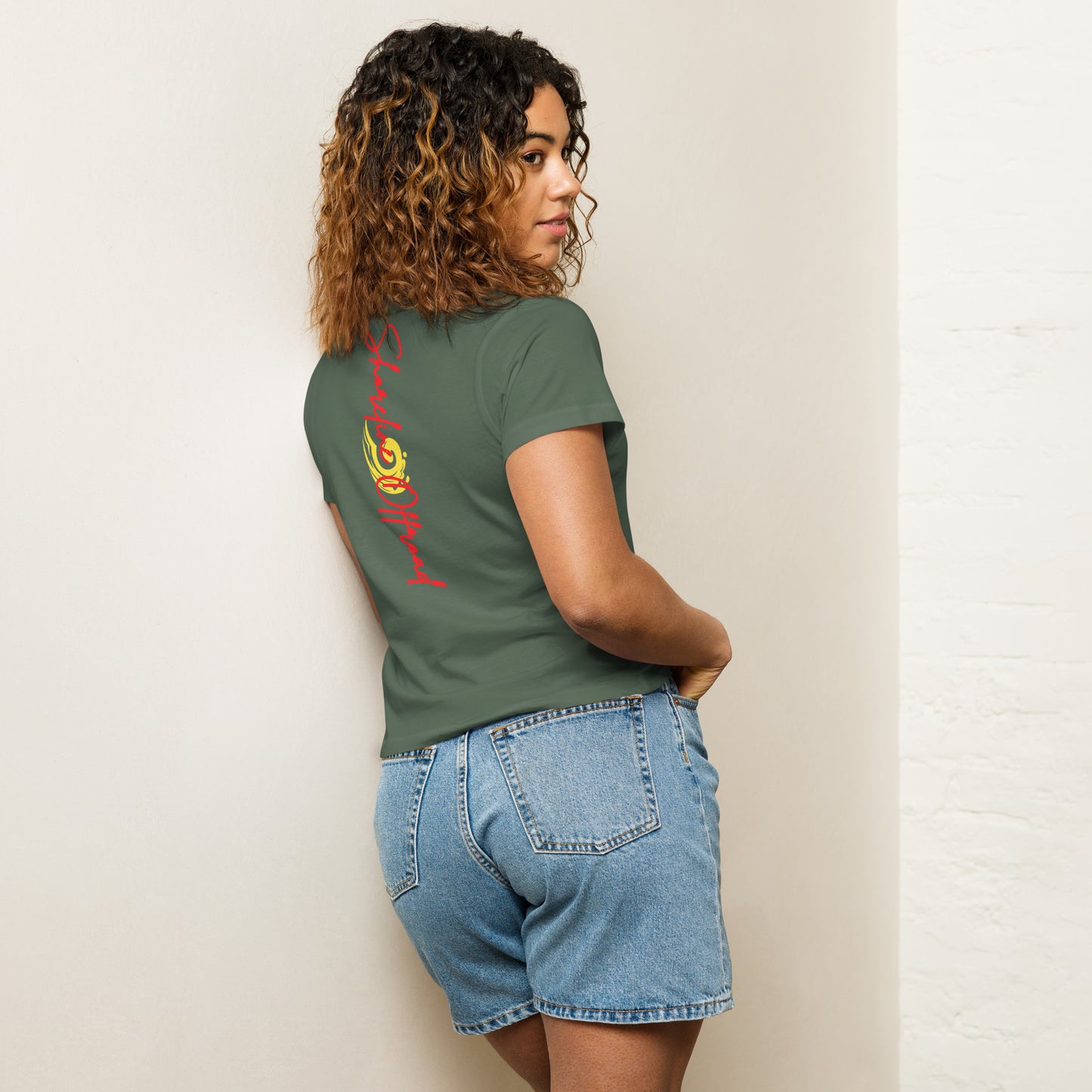 a woman wearing a green shirt and denim shorts