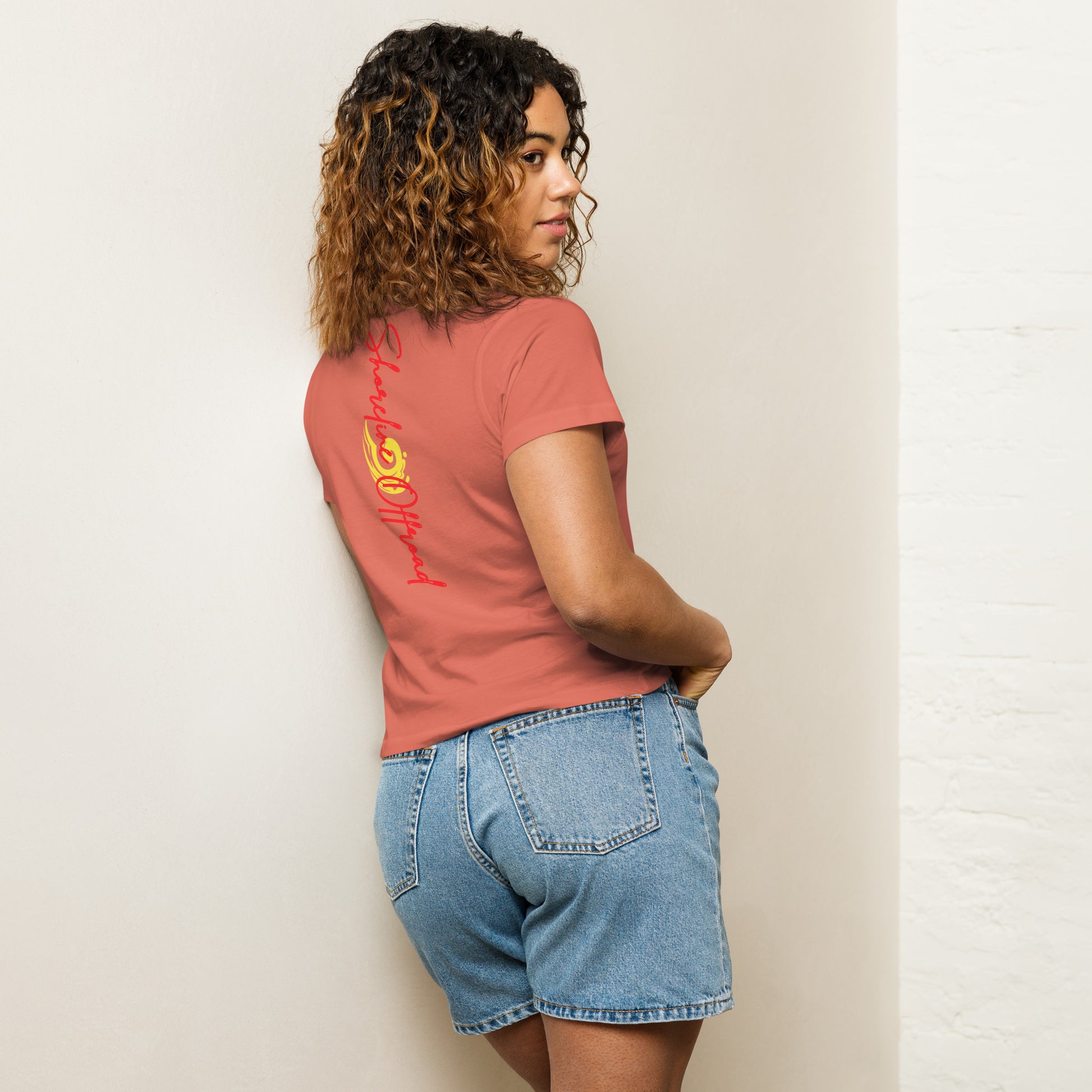 a woman standing against a wall with her back to the camera