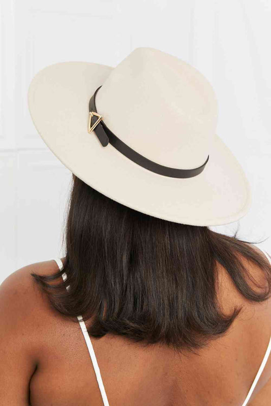 a woman wearing a white hat with a black ribbon