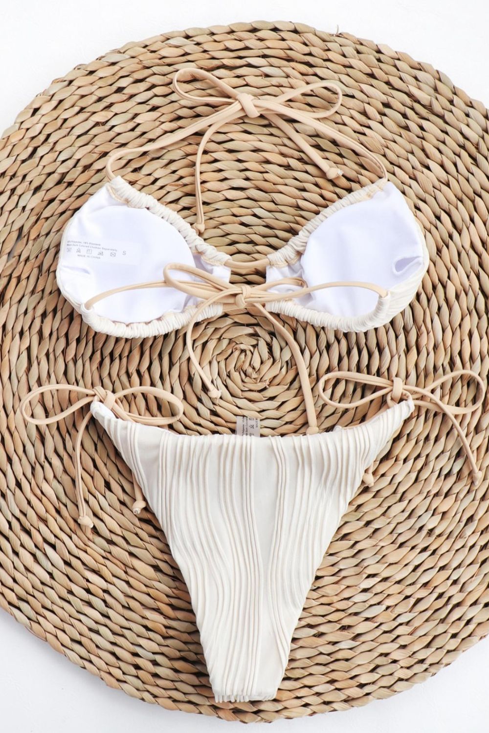 a woven piece of cloth with a white bikini on top of it
