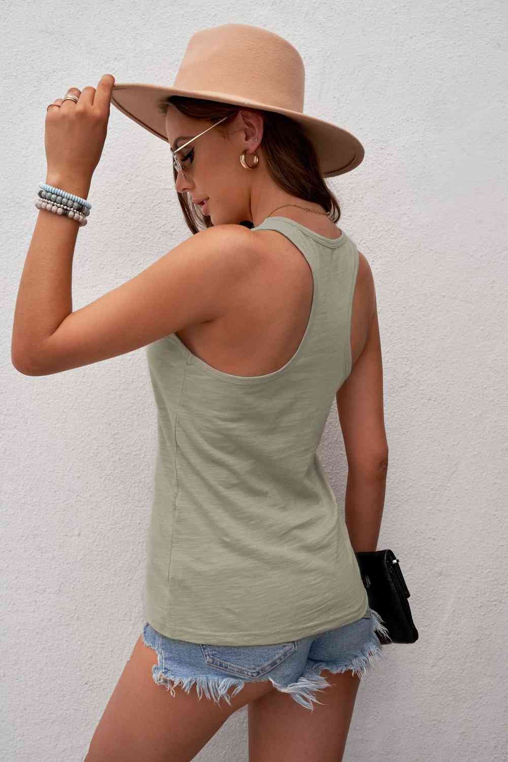 a woman wearing a hat and a tank top