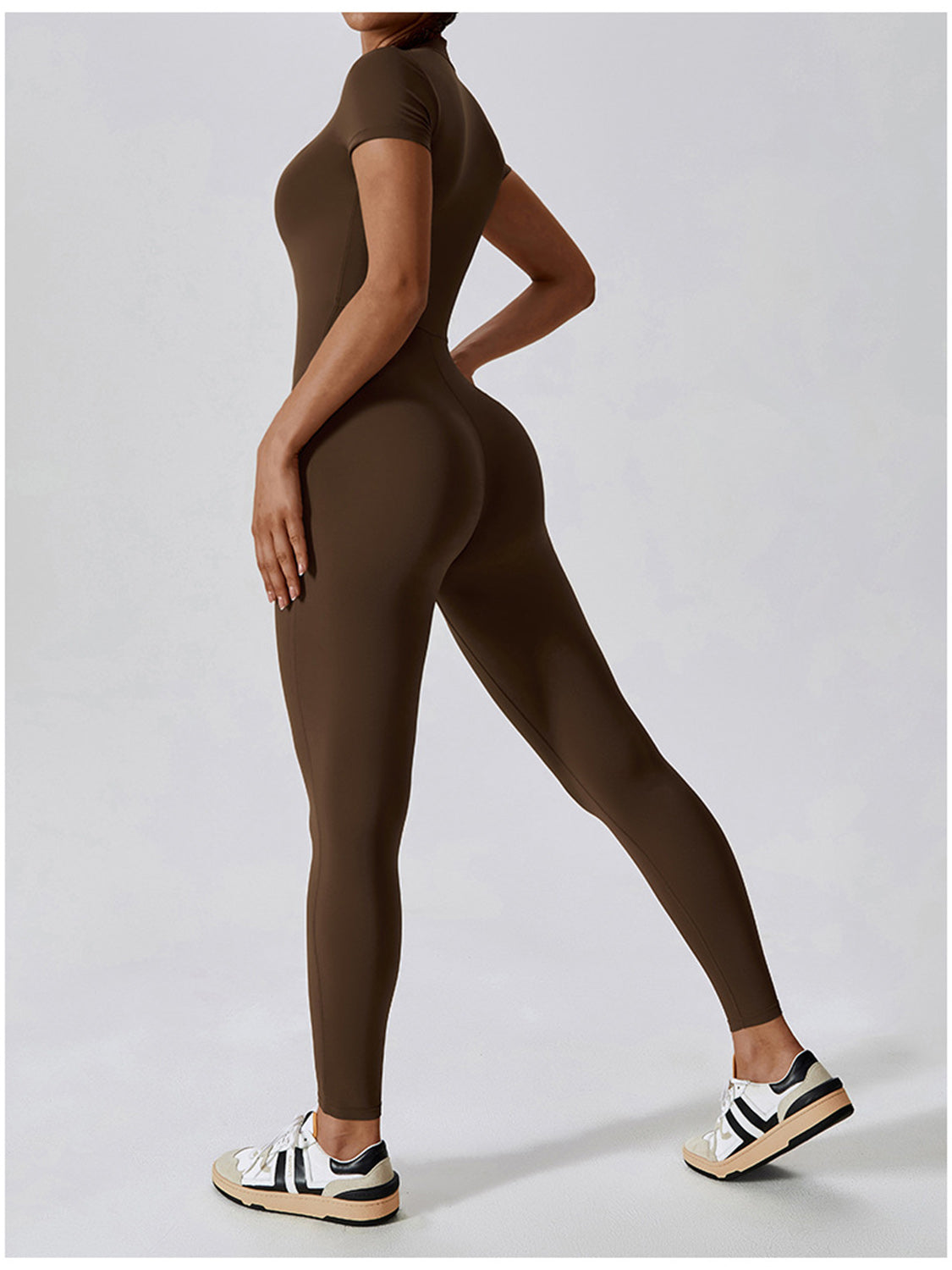 a woman in a brown bodysuit and sneakers