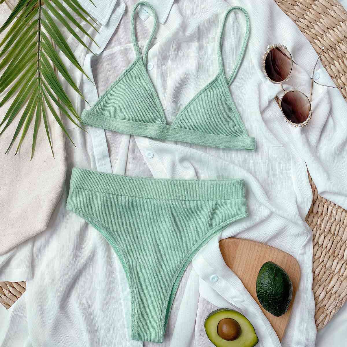 a woman's green bikinisuit with an avocado, sunglasses, and