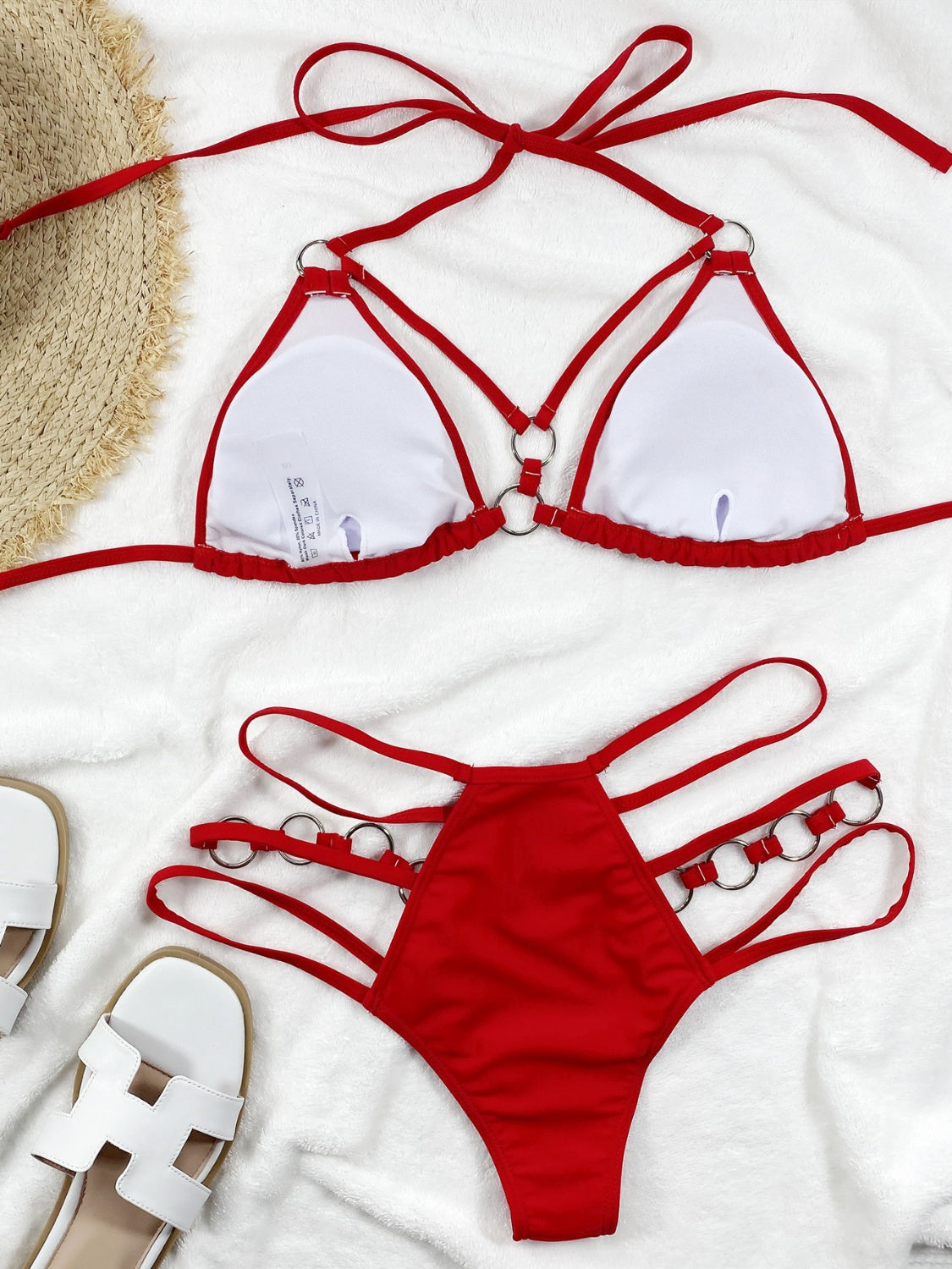 a red bikinisuit and a straw hat on a white towel