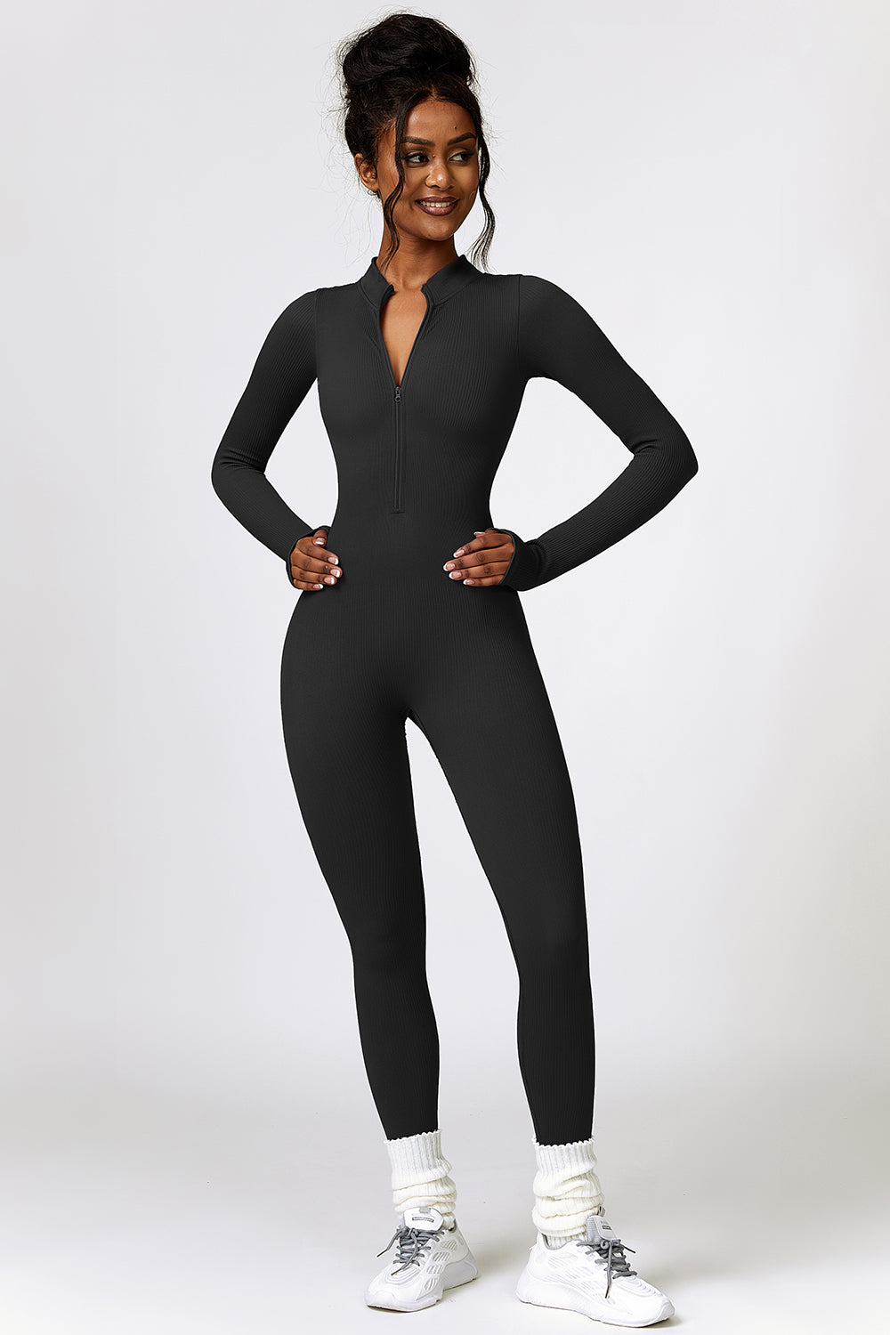 a woman in a black jumpsuit posing for a picture