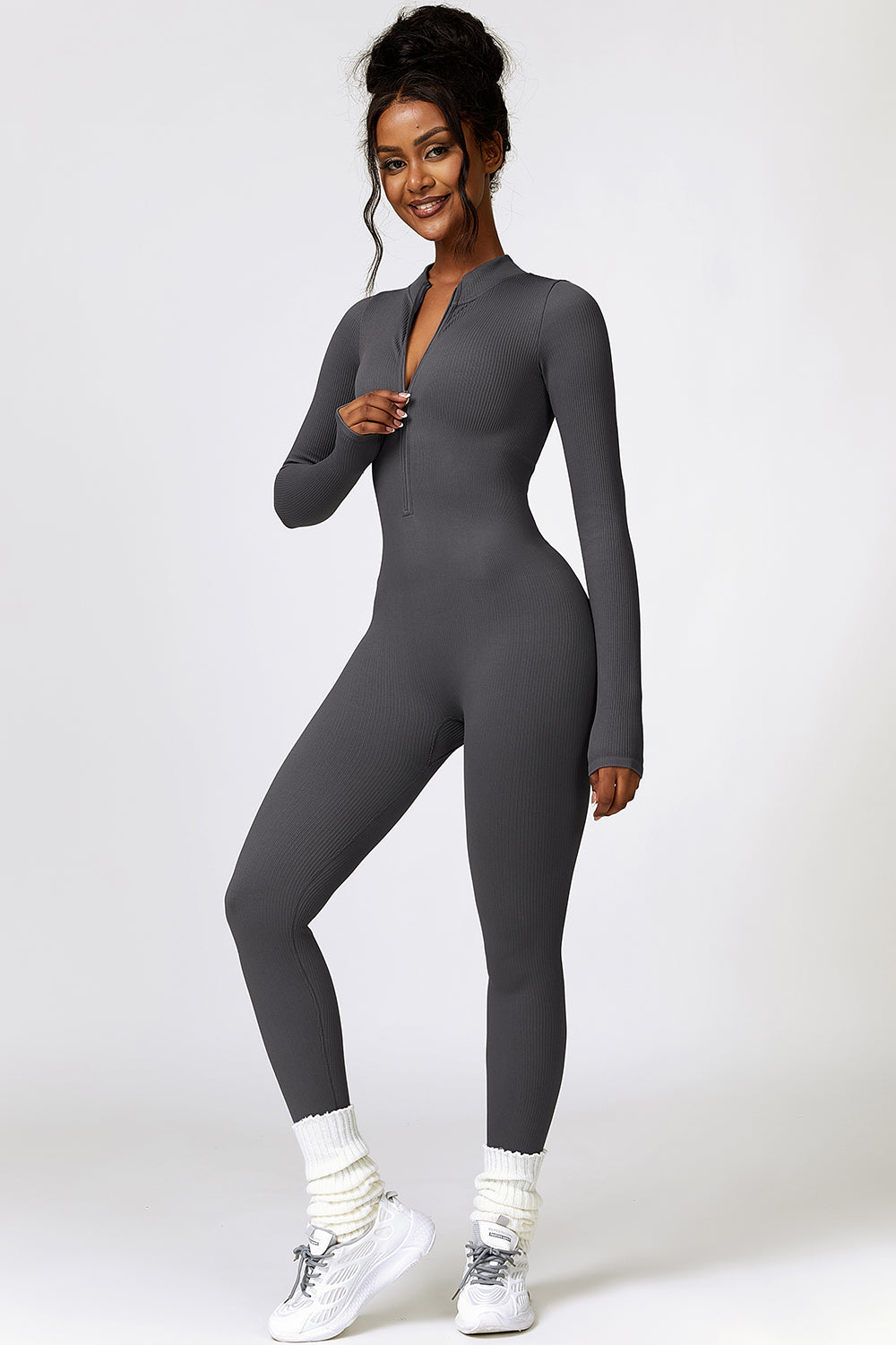 a woman in a grey bodysuit posing for a picture