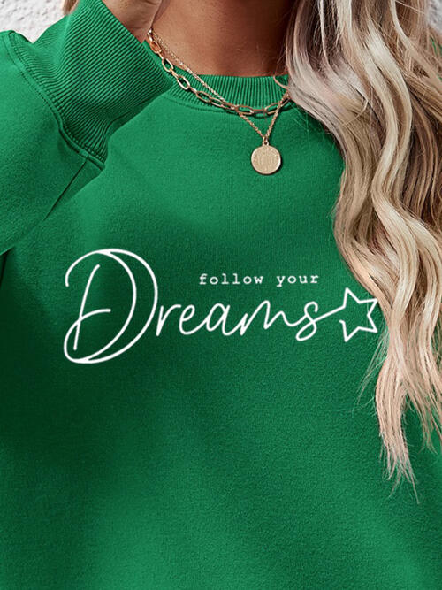a woman wearing a green sweatshirt that says follow your dreams