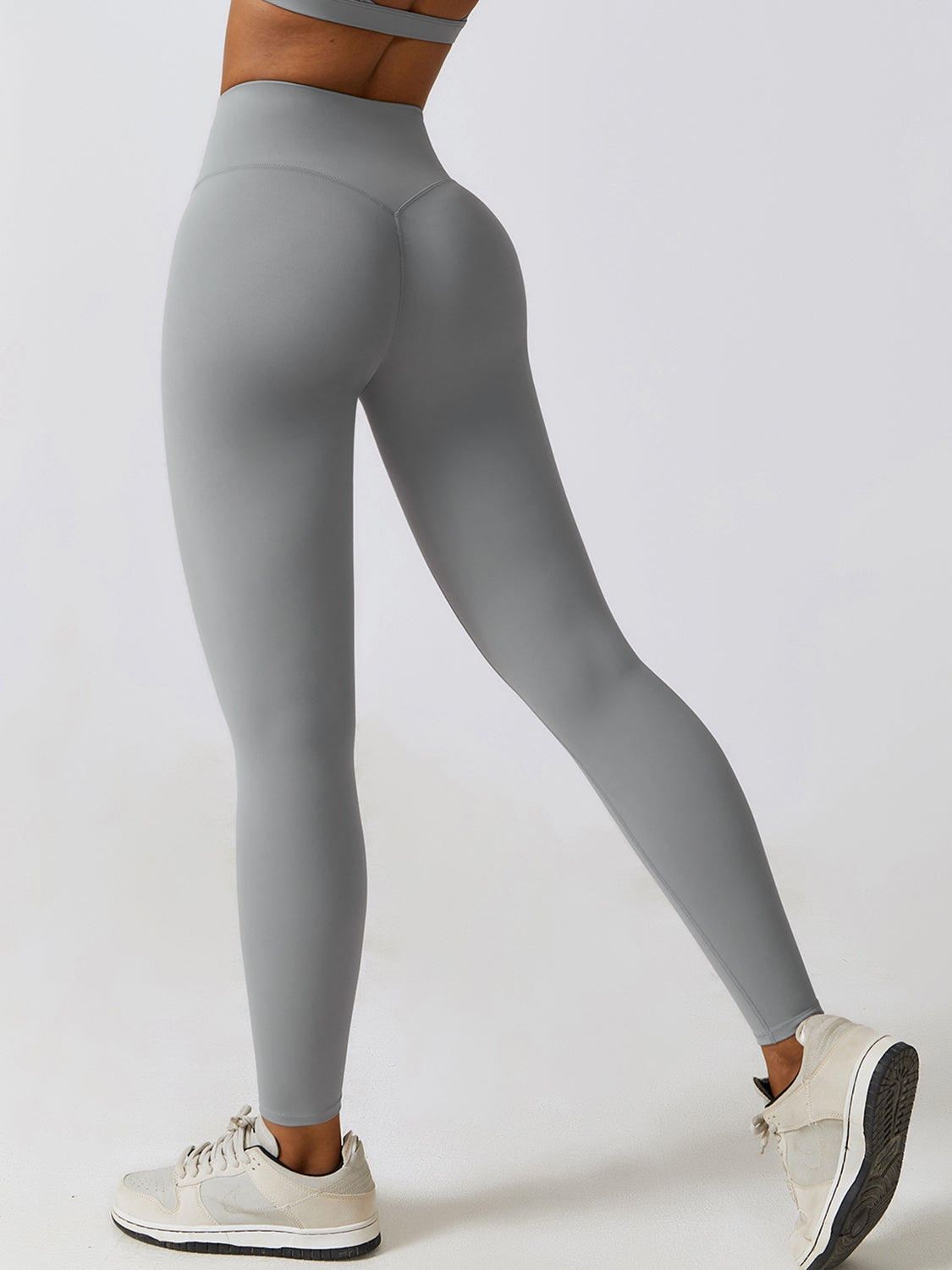 a woman in grey leggings with her hands on her hips