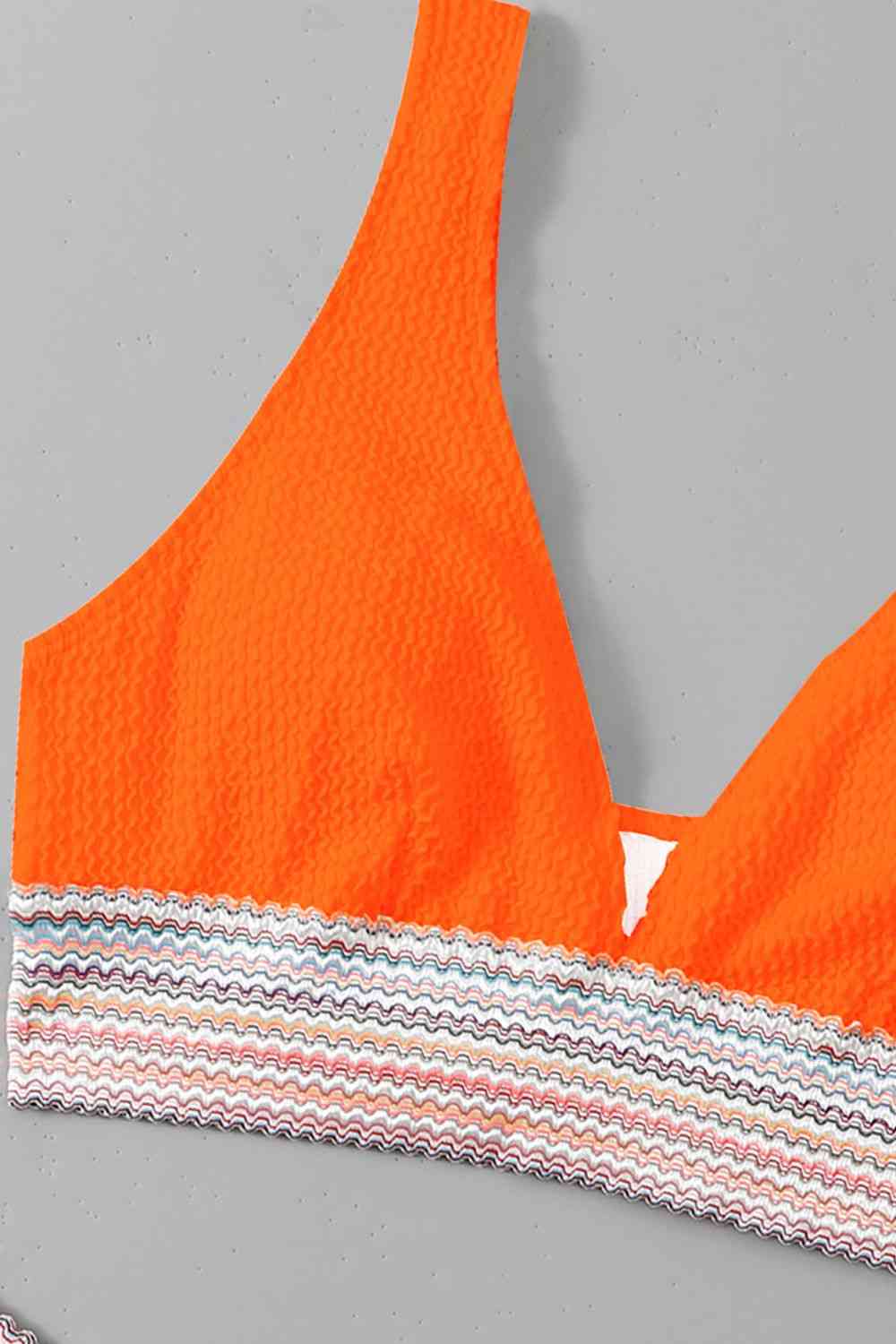 an orange bikini top with a white triangle on it