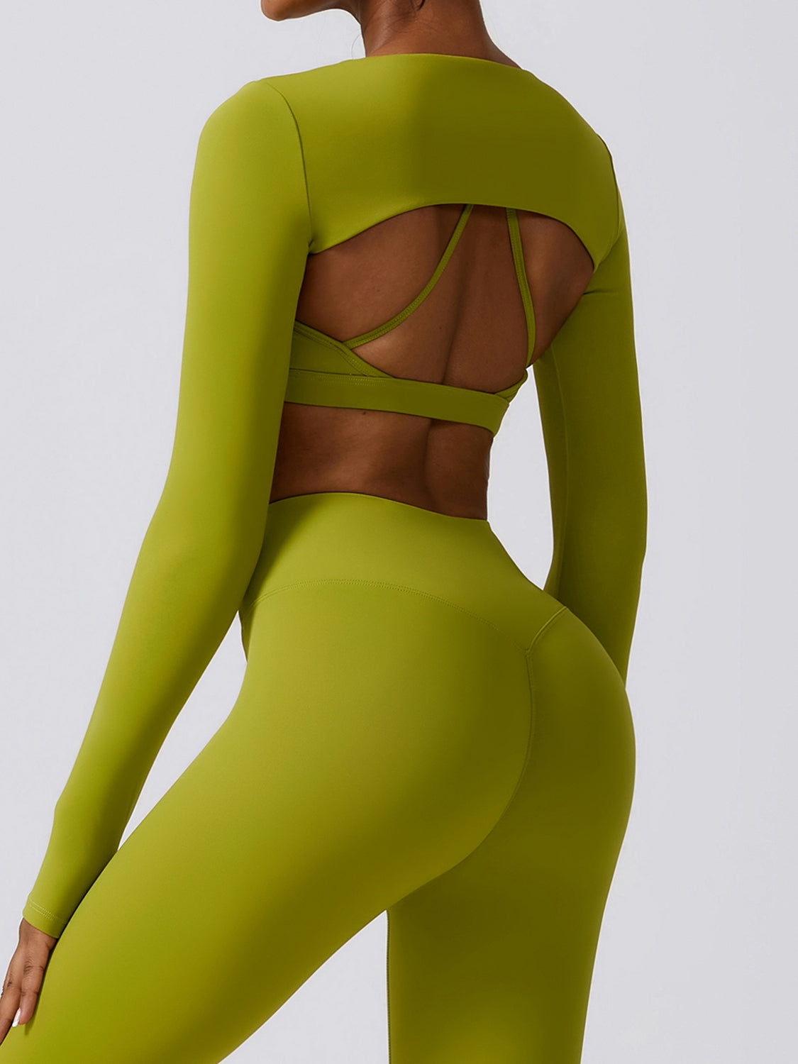 a woman in a green bodysuit with a cut out back