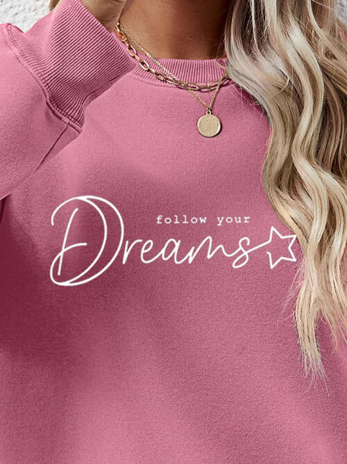 a woman wearing a pink sweatshirt that says follow your dreams