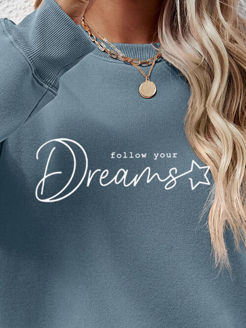 a woman wearing a blue sweatshirt that says follow your dreams