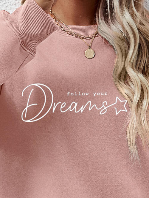 a woman wearing a pink sweatshirt that says follow your dreams