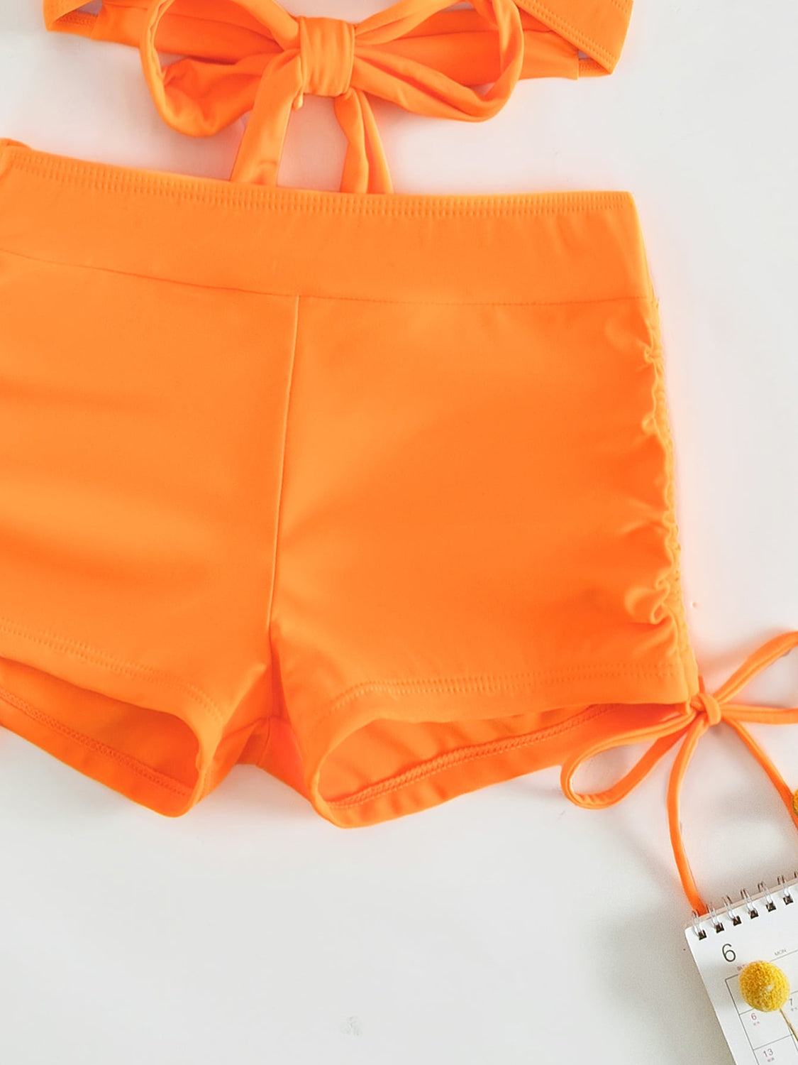 a pair of orange shorts with a tie around the waist