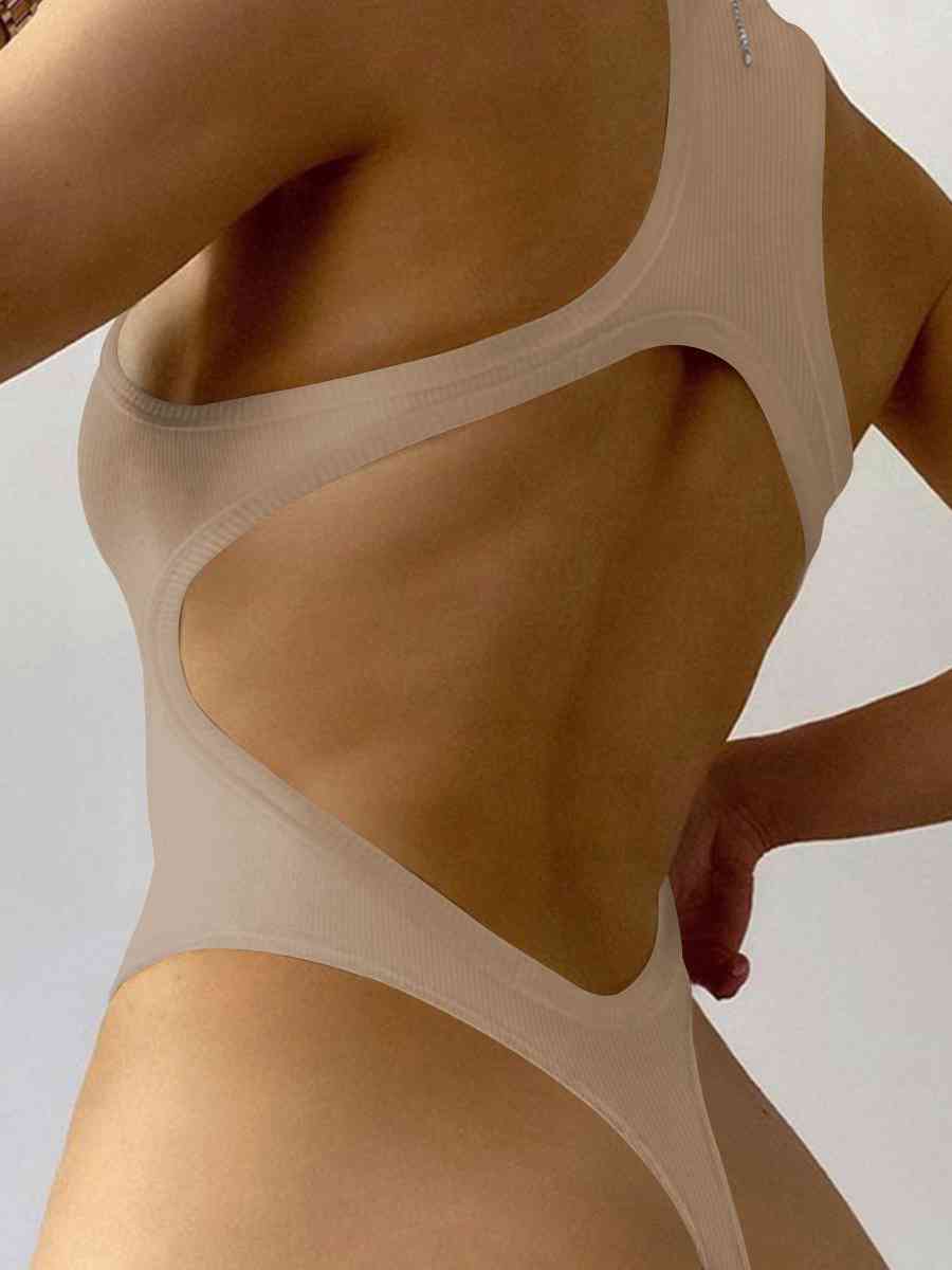 a woman wearing a tan bra with her hands on her hips