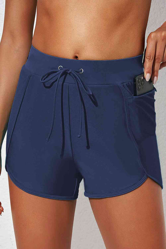 a woman in blue shorts holding a cell phone