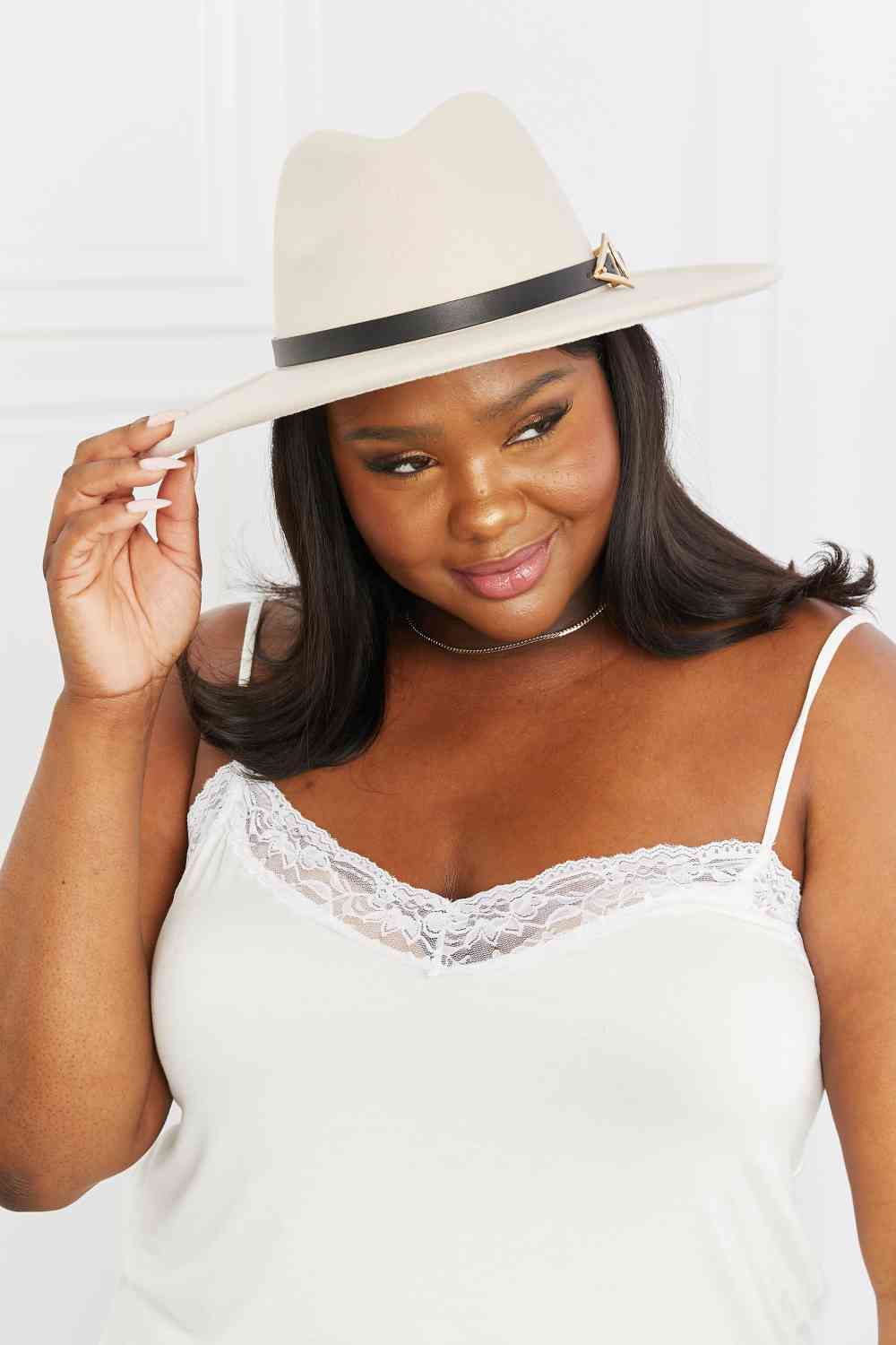 a woman wearing a white top and a hat
