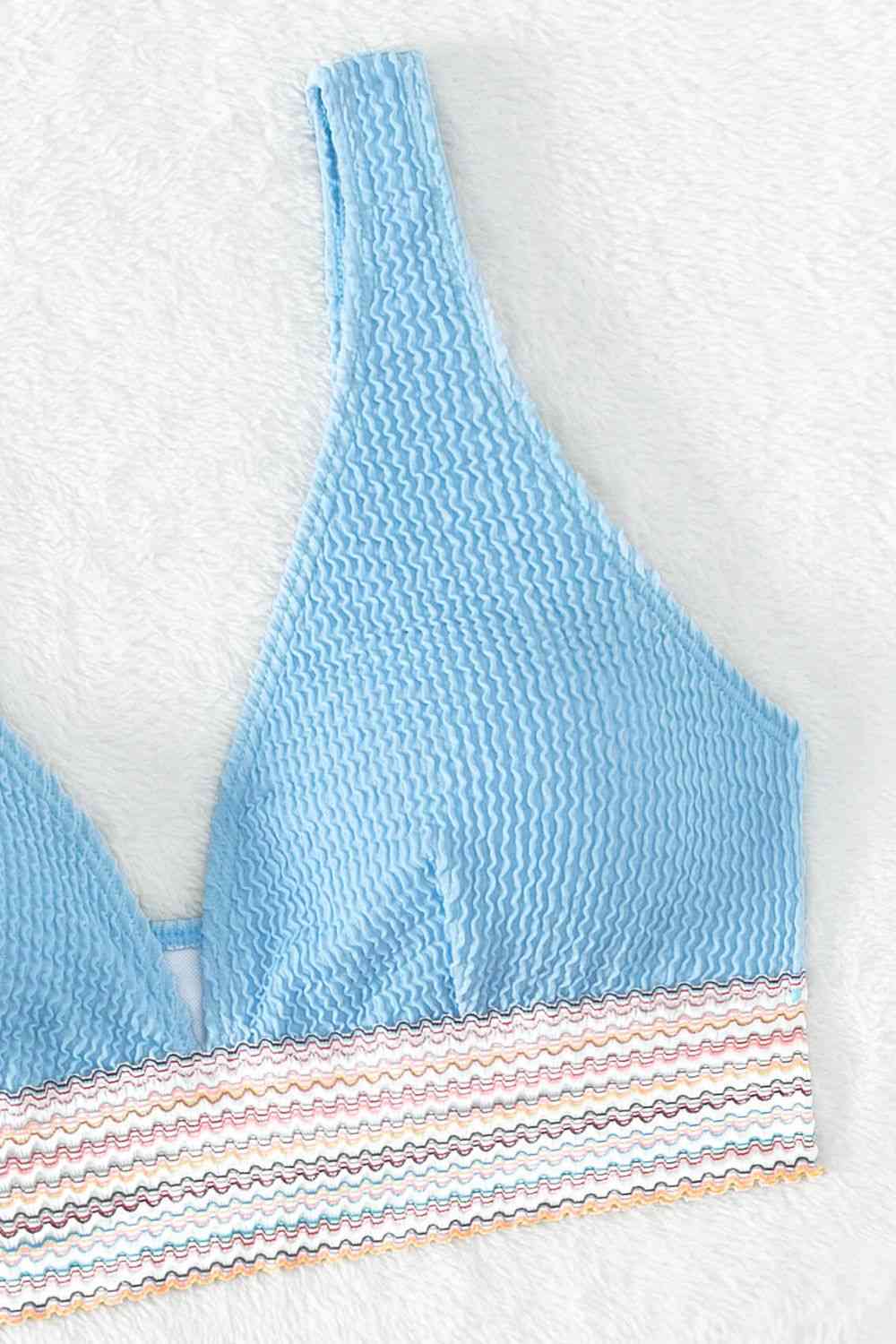 a blue bikini top with a striped bottom