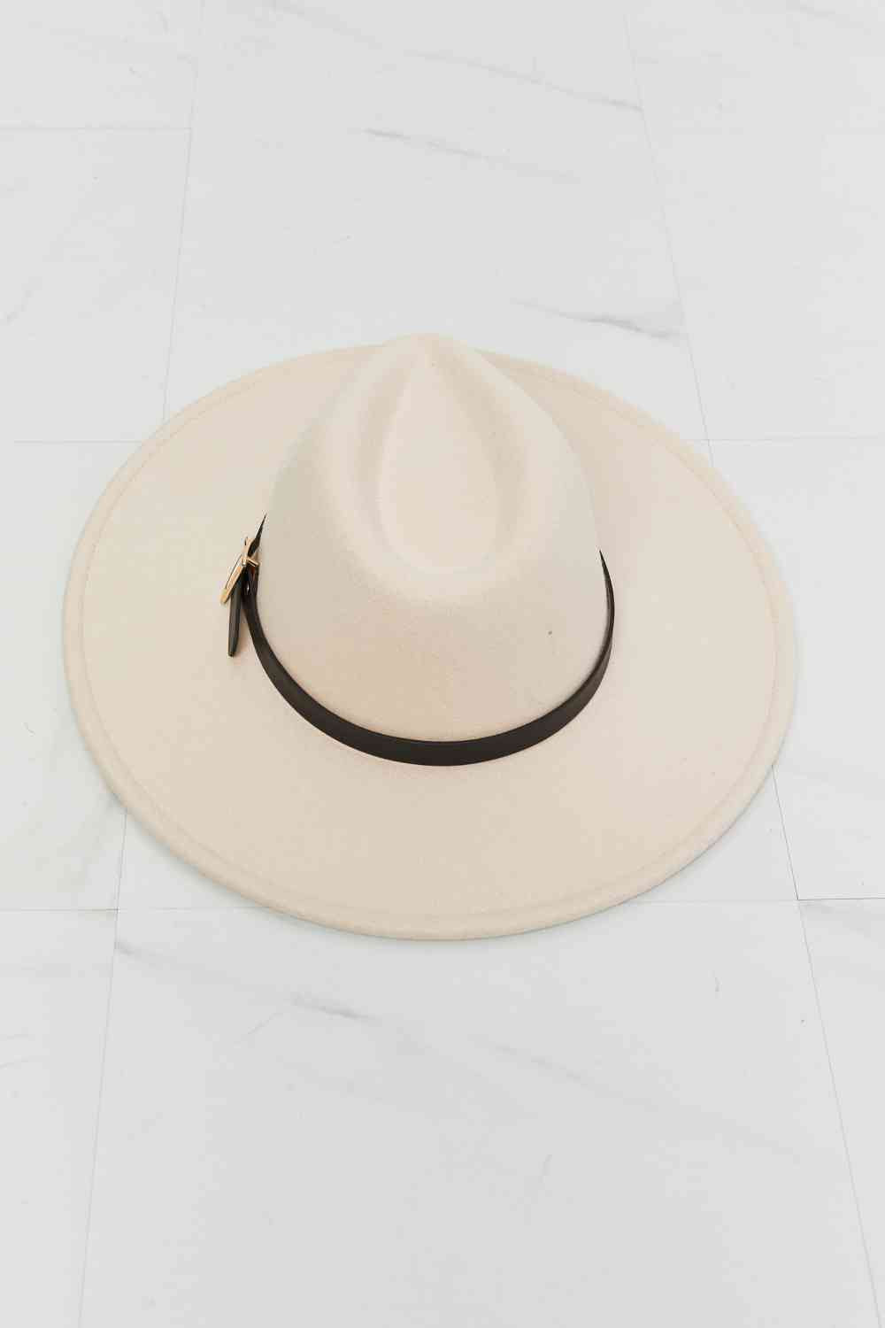 a white hat with a black ribbon around the brim